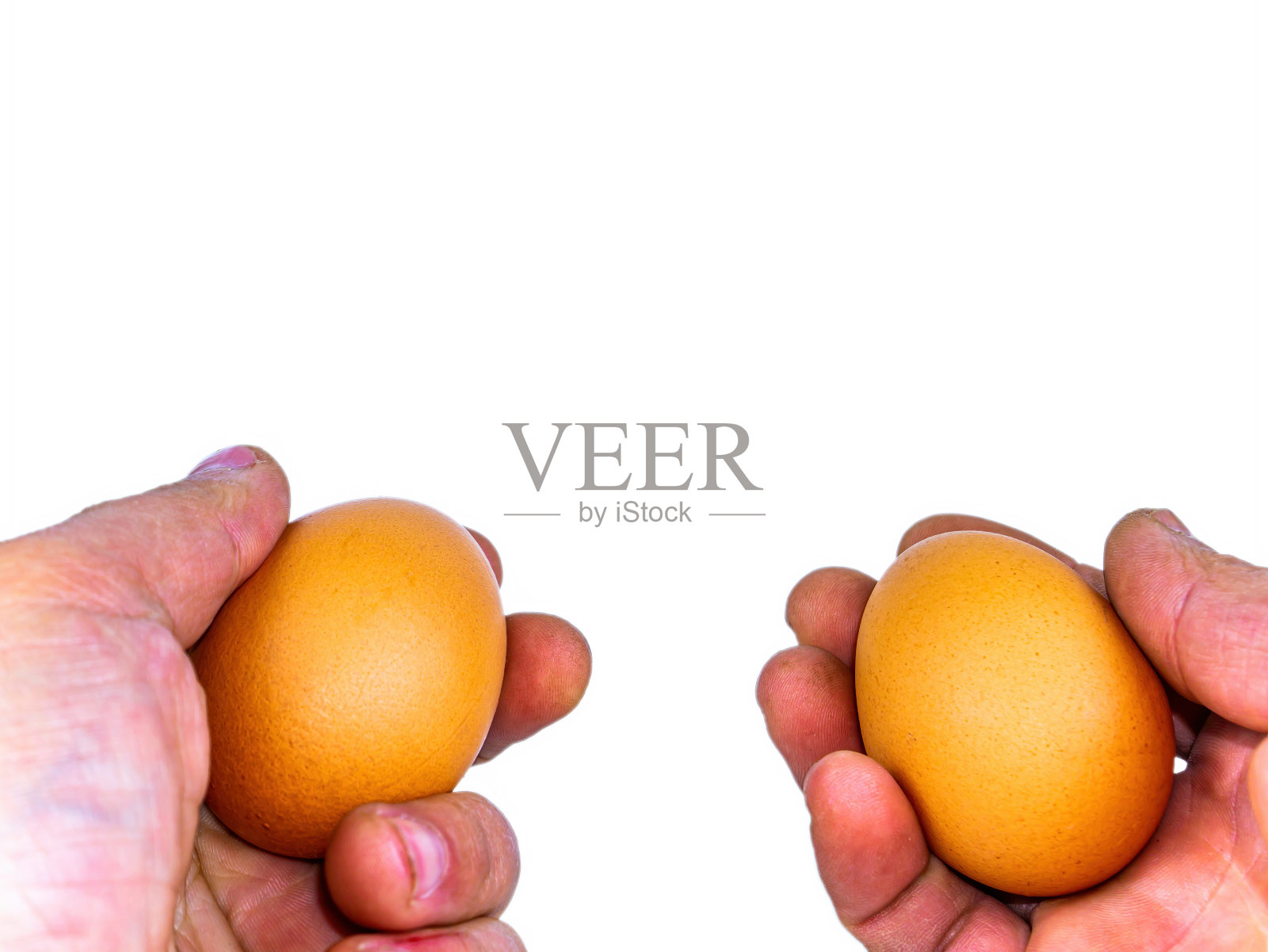 两个鸡蛋在一个男人的手里。照片摄影图片