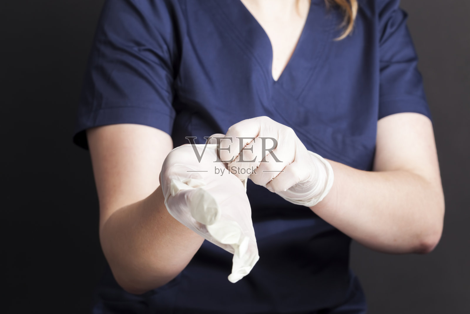 一个穿着蓝色医疗服的人戴着白色乳胶手套照片摄影图片