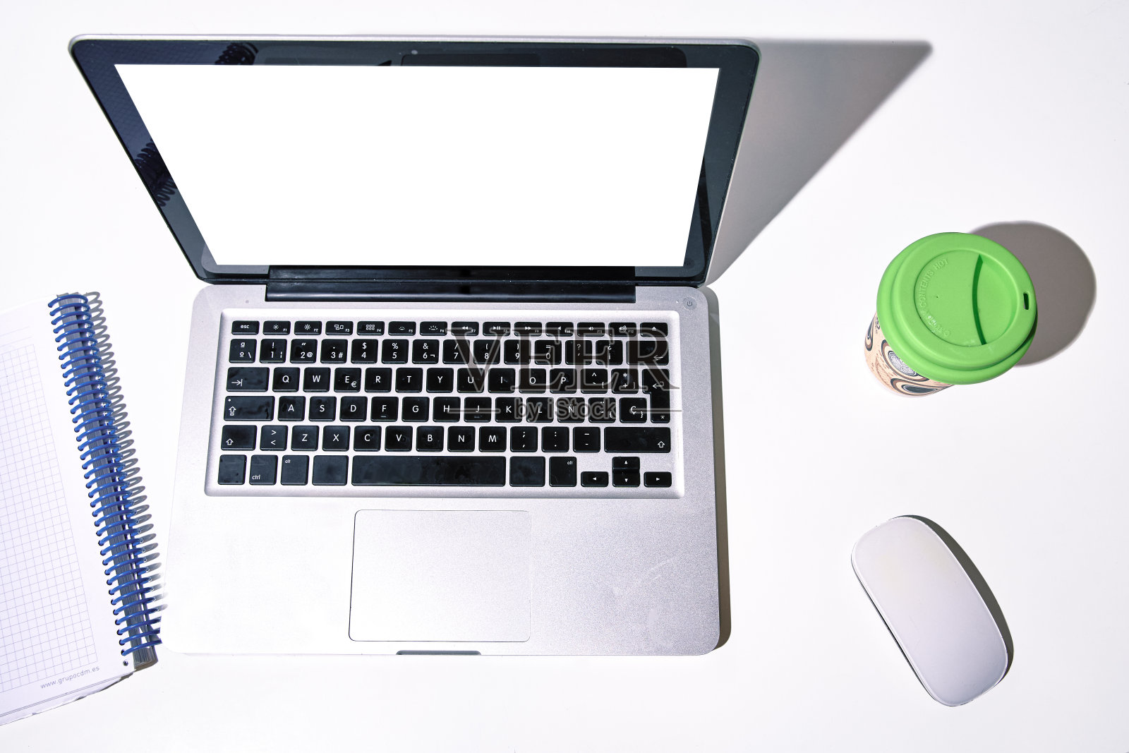 白底白屏的笔记本电脑,旁边放着咖啡和笔记本。照片摄影图片