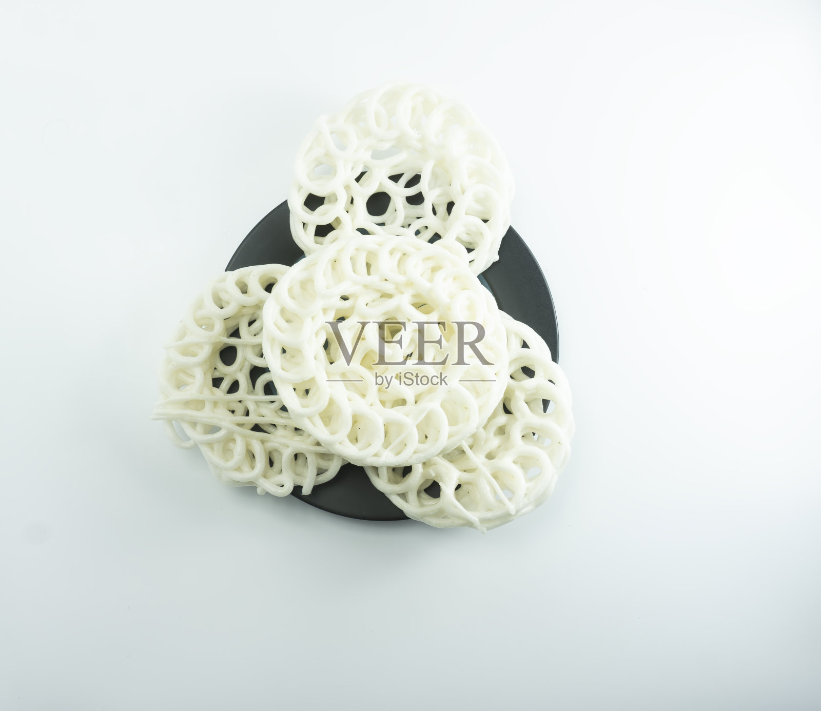 Krupuk或Kerupuk,印尼传统爆竹,放置在绿色托斯卡盘容器,在白色背景照片摄影图片