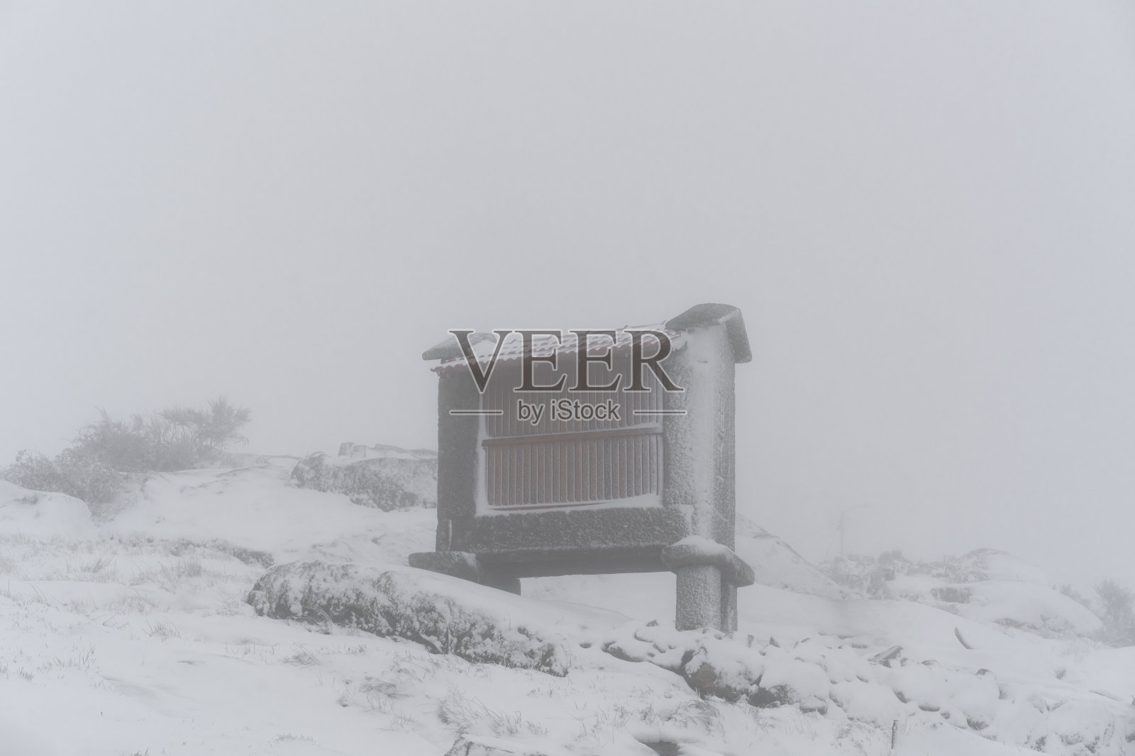 埃斯皮埃罗传统结构的玉米储存在雪白色的冬季景观,在葡萄牙北部降雪照片摄影图片