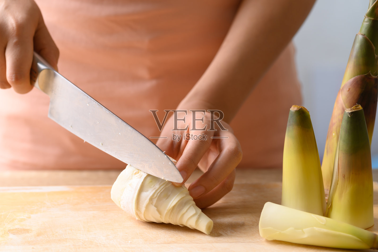 手持菜刀,切去皮的竹笋照片摄影图片