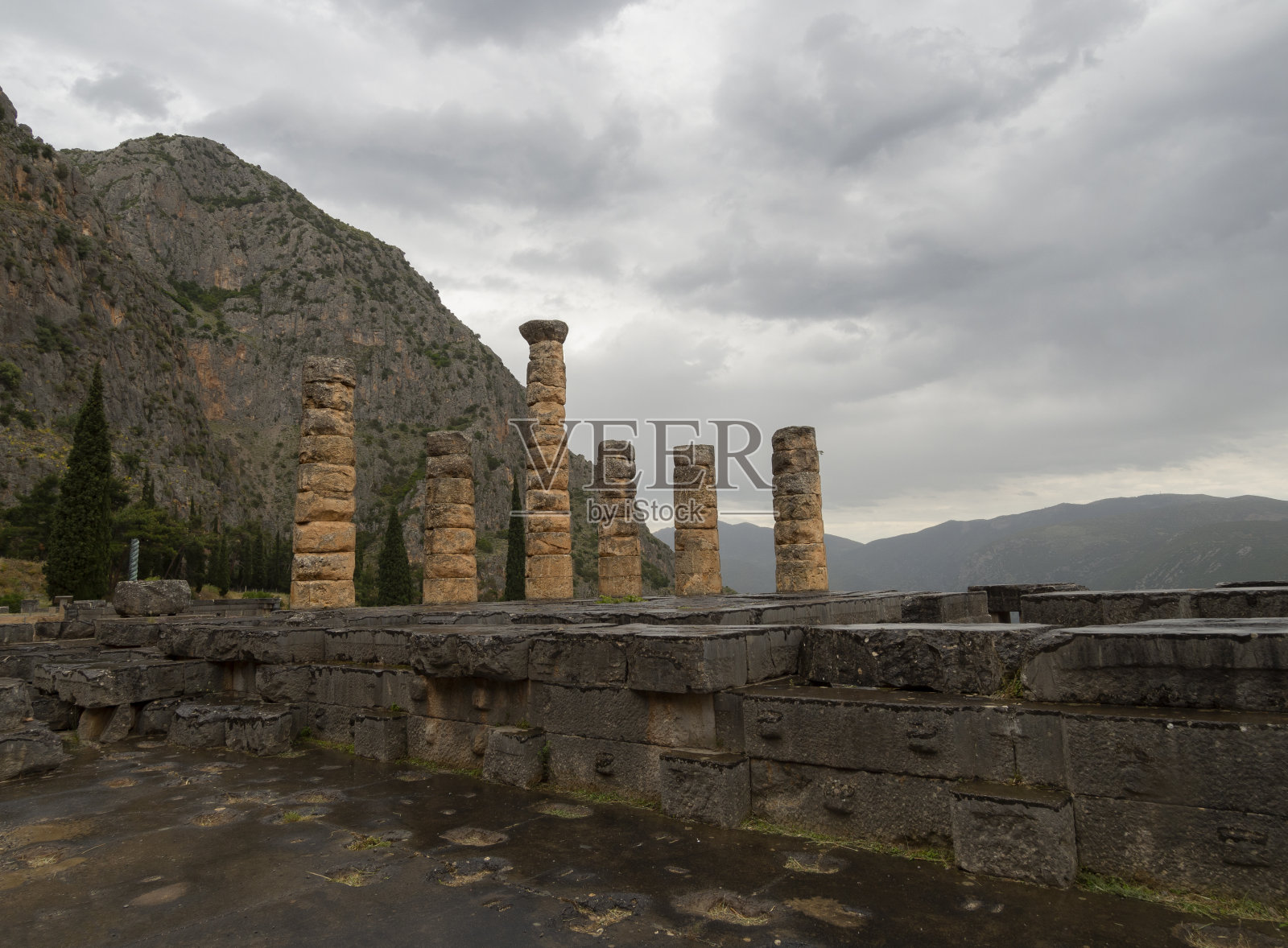 全景阿波罗神庙和德尔菲三脚架(高原三脚架,蛇柱)在德尔福的背景山和天空与希腊的云照片摄影图片
