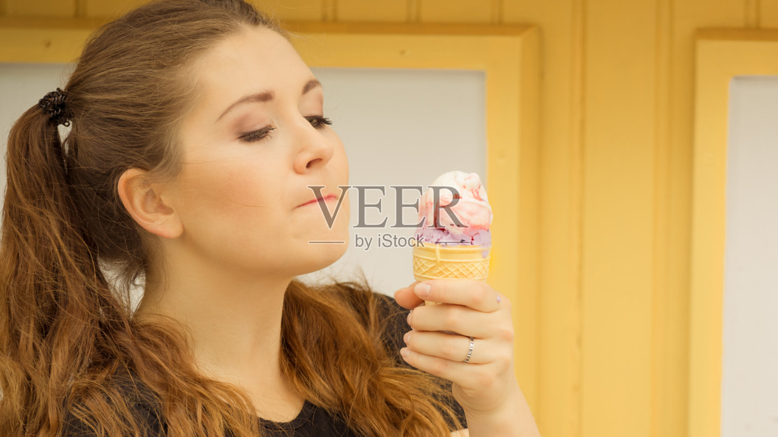 年轻女子在吃冰淇淋照片摄影图片