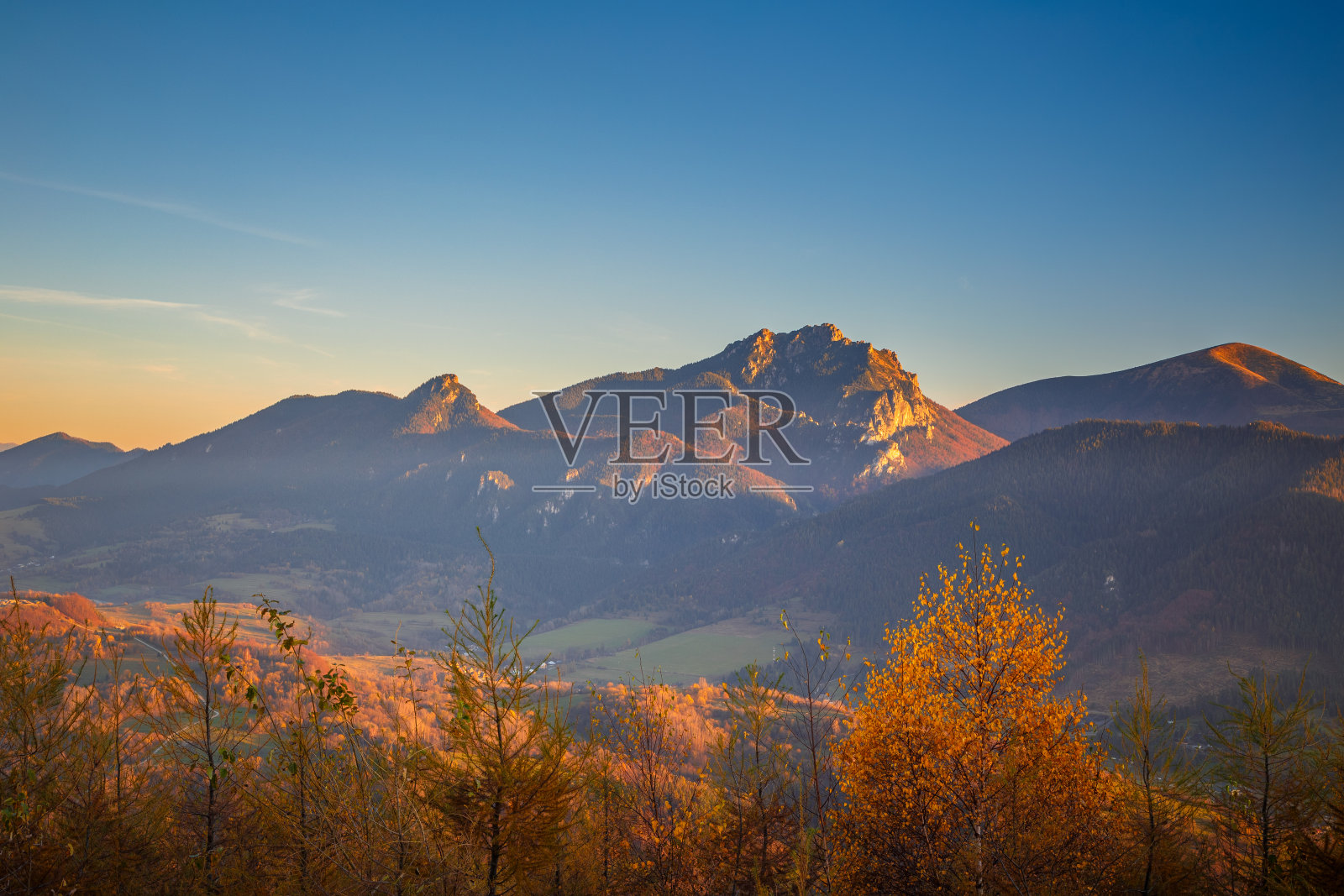 秋天的乡村景观与山峰的背景。照片摄影图片