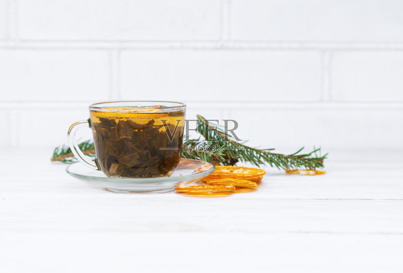 红茶。一杯有干橙和迷迭香的茶。用干柑橘做的草药茶。白色背景上的红茶杯。照片摄影图片