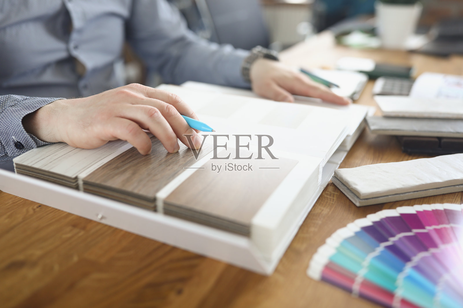 女设计师翻阅目录与样品木层压板的特写照片摄影图片
