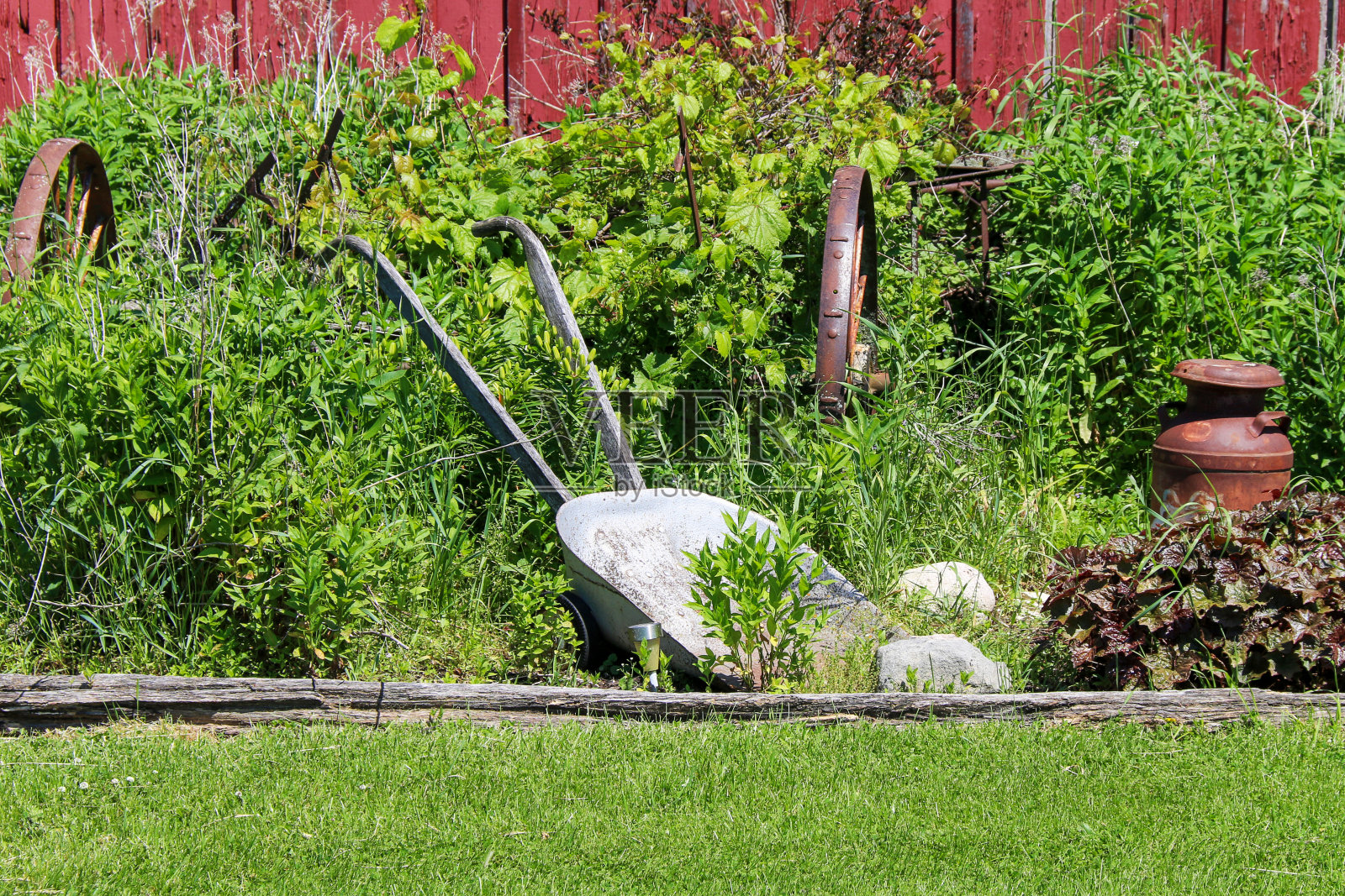 农村农场红色谷仓建筑与古董农具花园工具在明亮的阳光下展示照片摄影图片