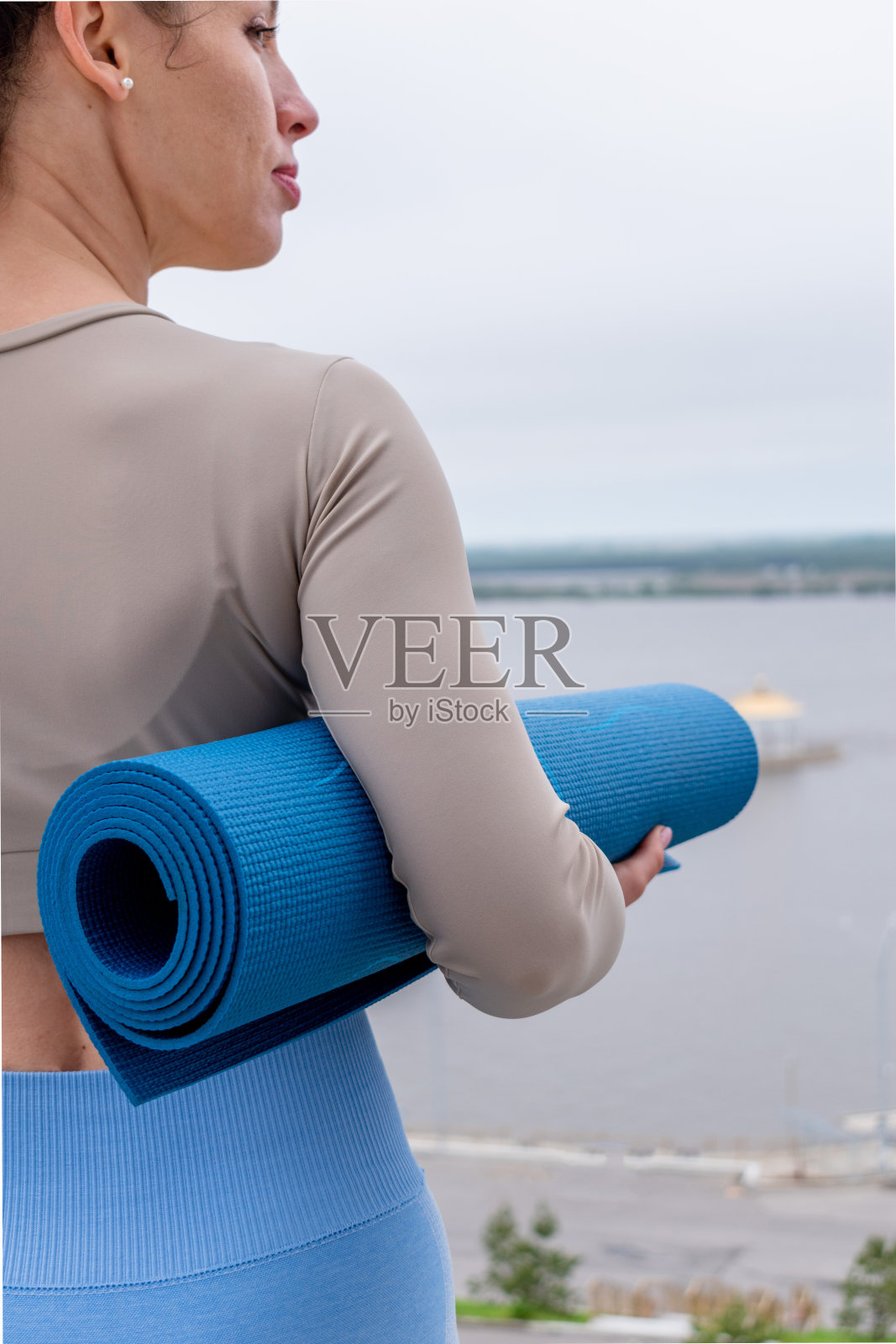 一名红发女子在公园户外上完瑜伽课后拿着垫子。本空间照片摄影图片