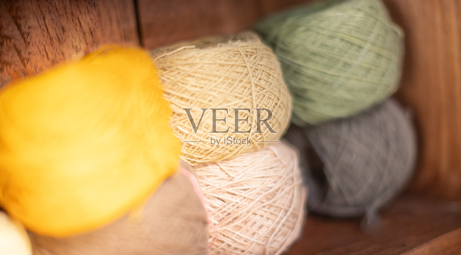 在冬季,把土色调的纱线放在木橱上,准备做衣服、毛衣或围巾。照片摄影图片