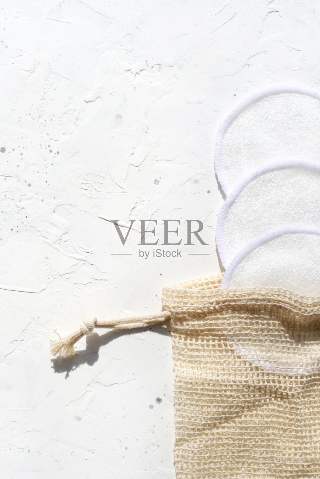 化妆品可洗的棉海绵设置在袋子上的白色背景特写。天然可重复使用卸妆垫照片摄影图片