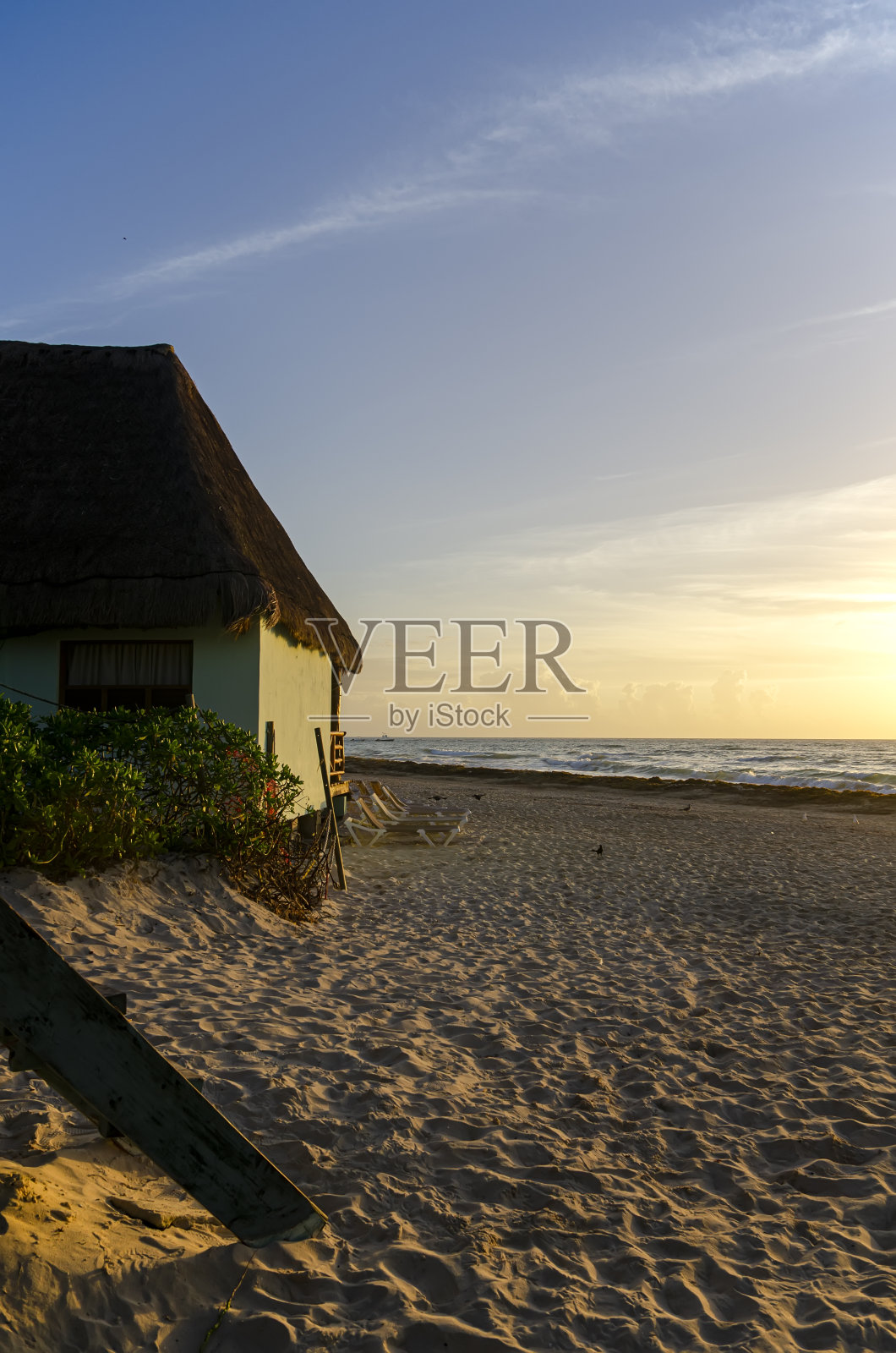墨西哥加勒比海滩上的日出,沙滩上的滨水别墅。照片摄影图片