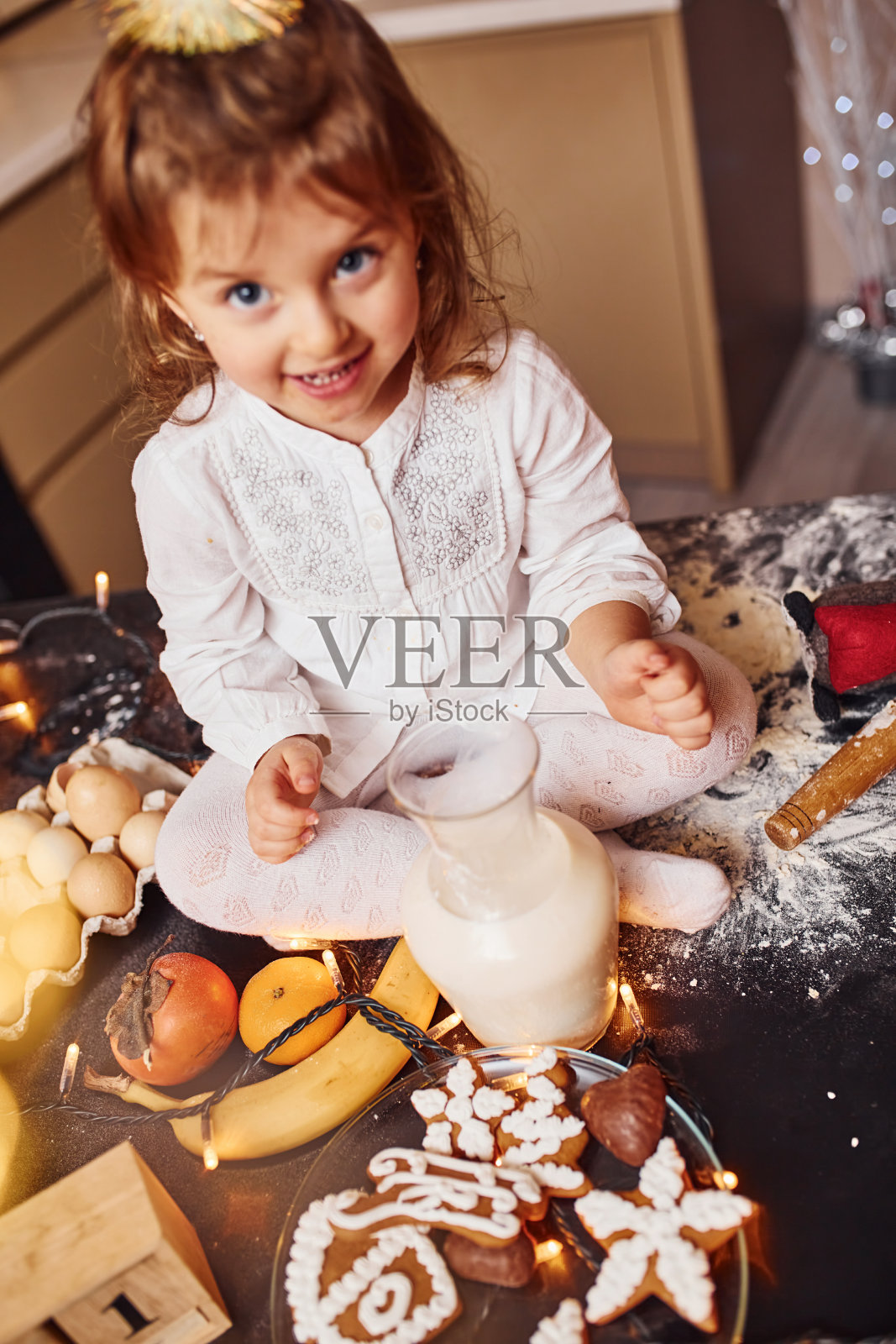 可爱的小女孩坐在厨房里吃东西照片摄影图片