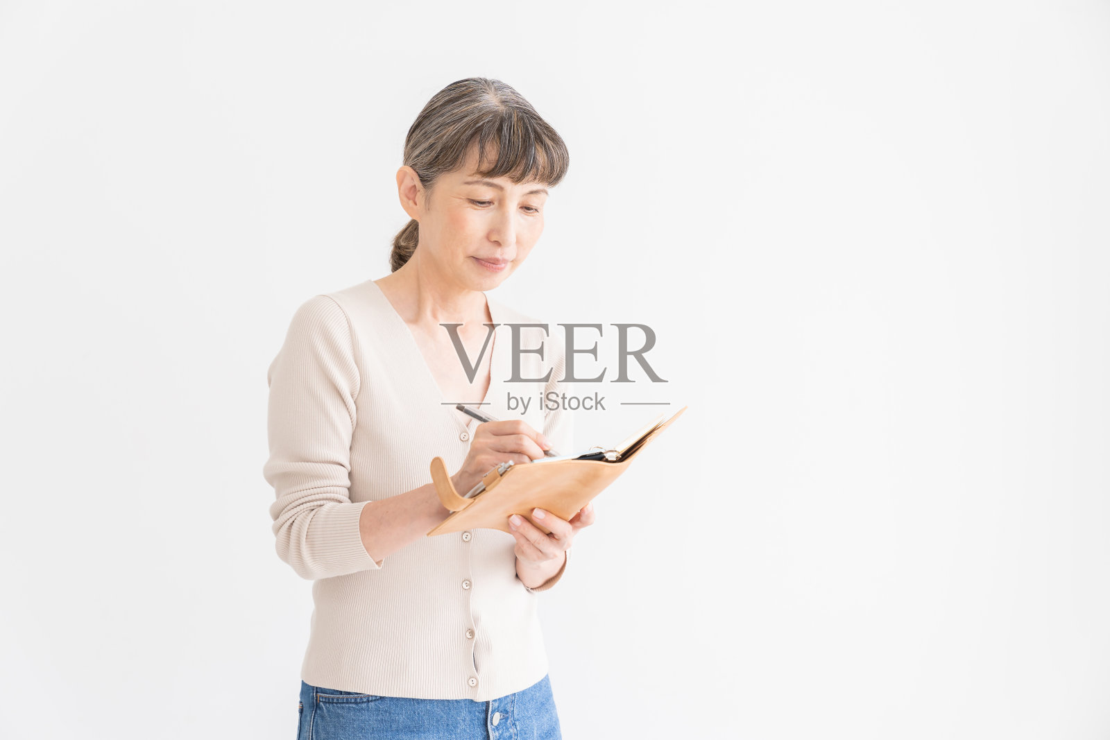 填写日程表的老年妇女照片摄影图片