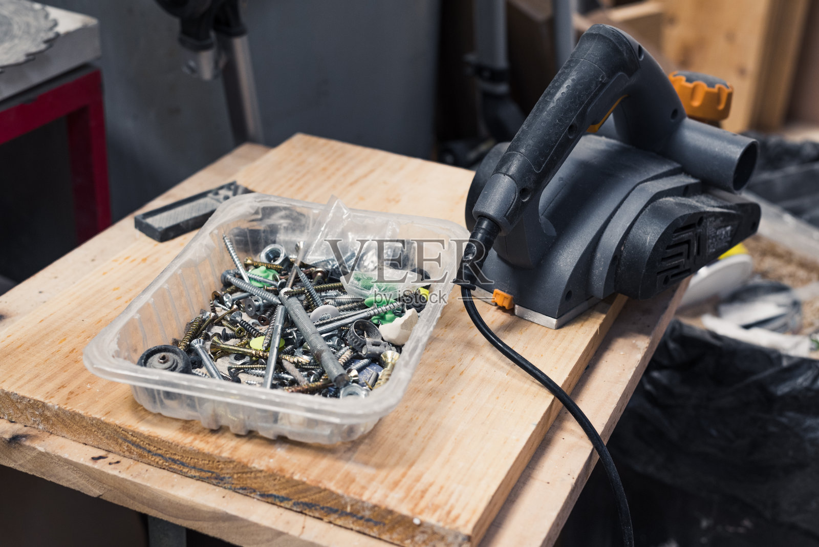一个有螺丝的盒子和一个木制的电动砂光机照片摄影图片
