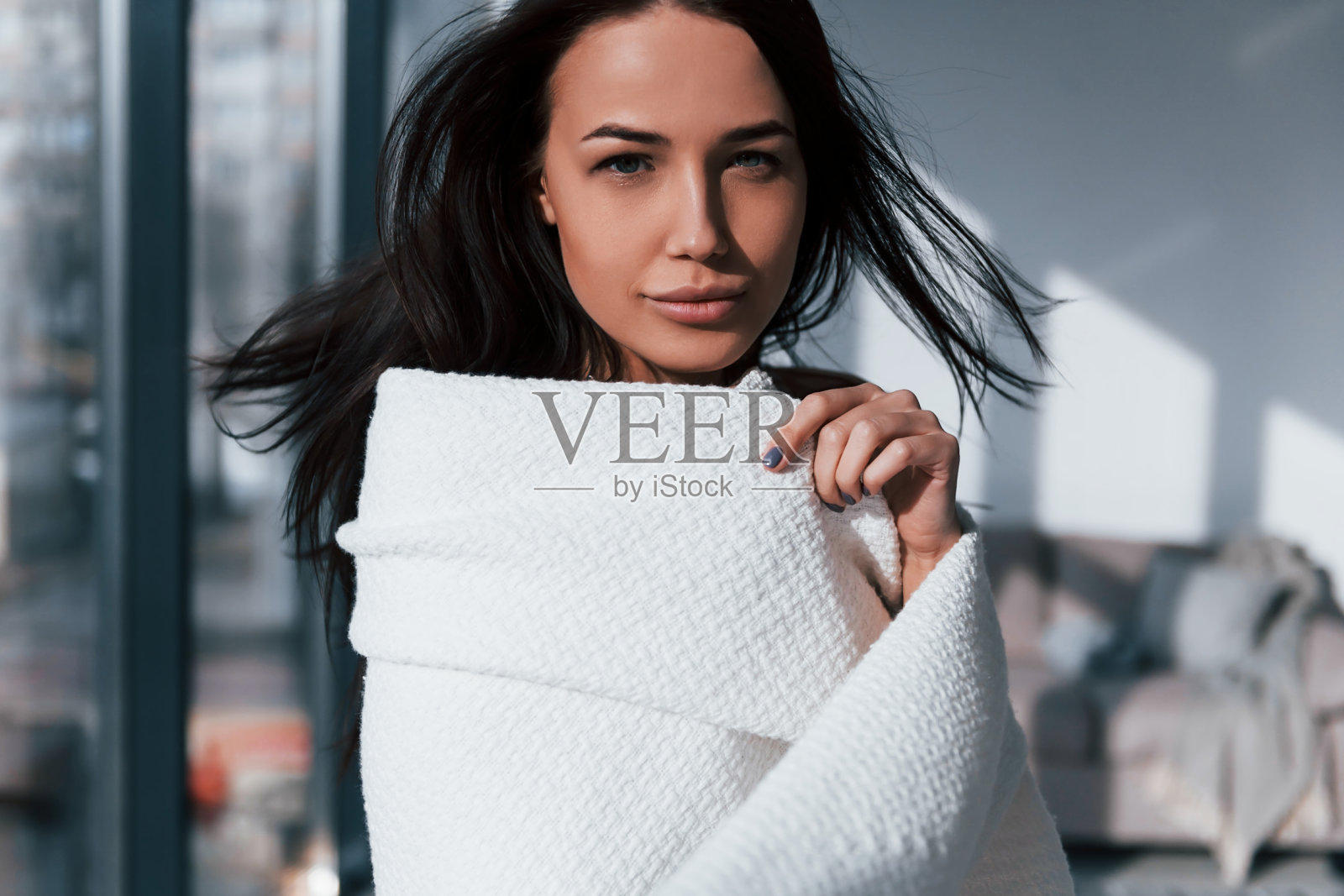 年轻美丽的黑发姑娘站在室内,用白毛巾盖住身体照片摄影图片