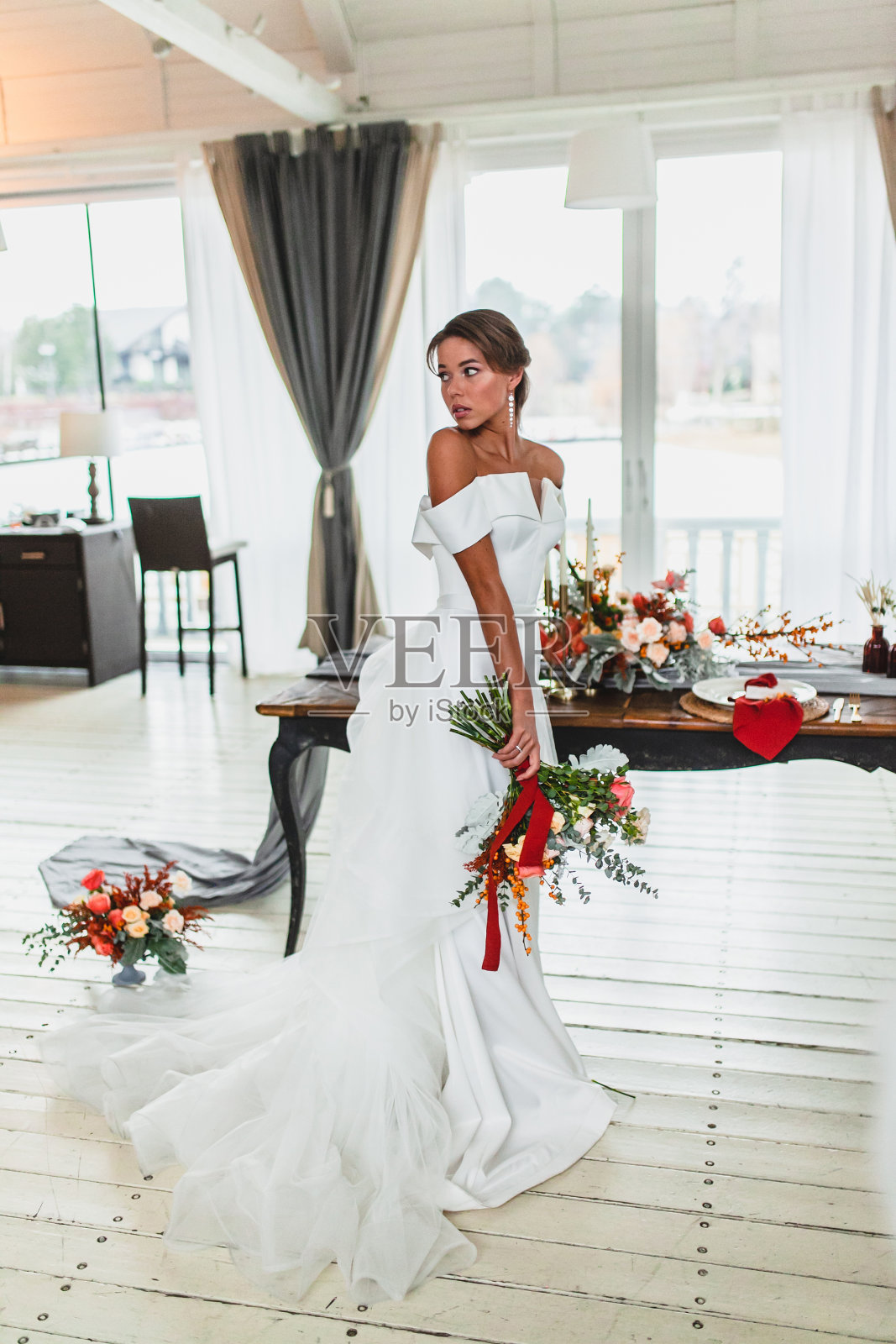 时尚和美丽的年轻新娘与新娘花束摆姿势前的婚礼仪式照片摄影图片