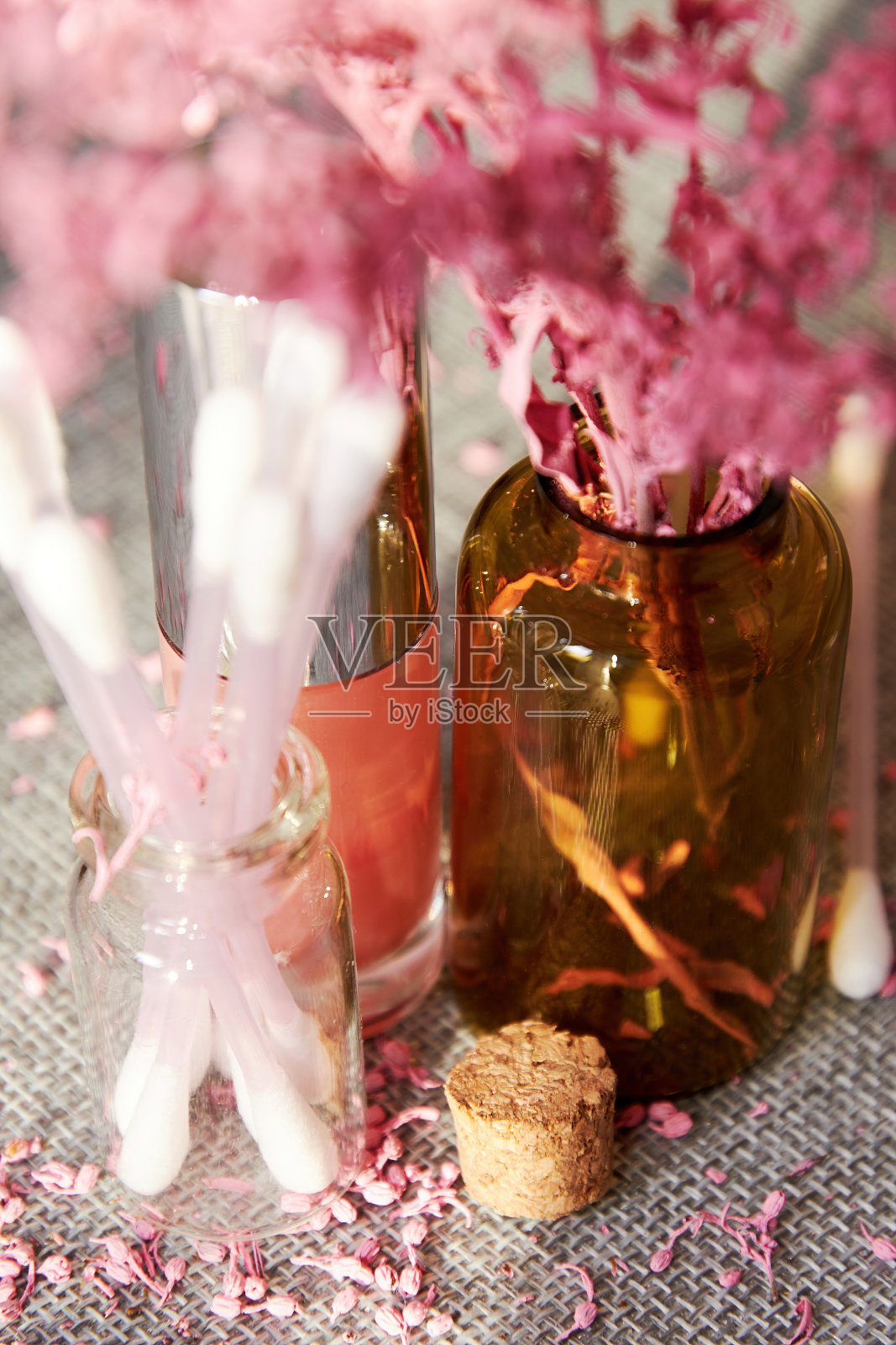 在商店的化妆桌上有闪亮的粉色唇彩瓶和化妆品罐。时尚和化妆品的背景和符号照片摄影图片