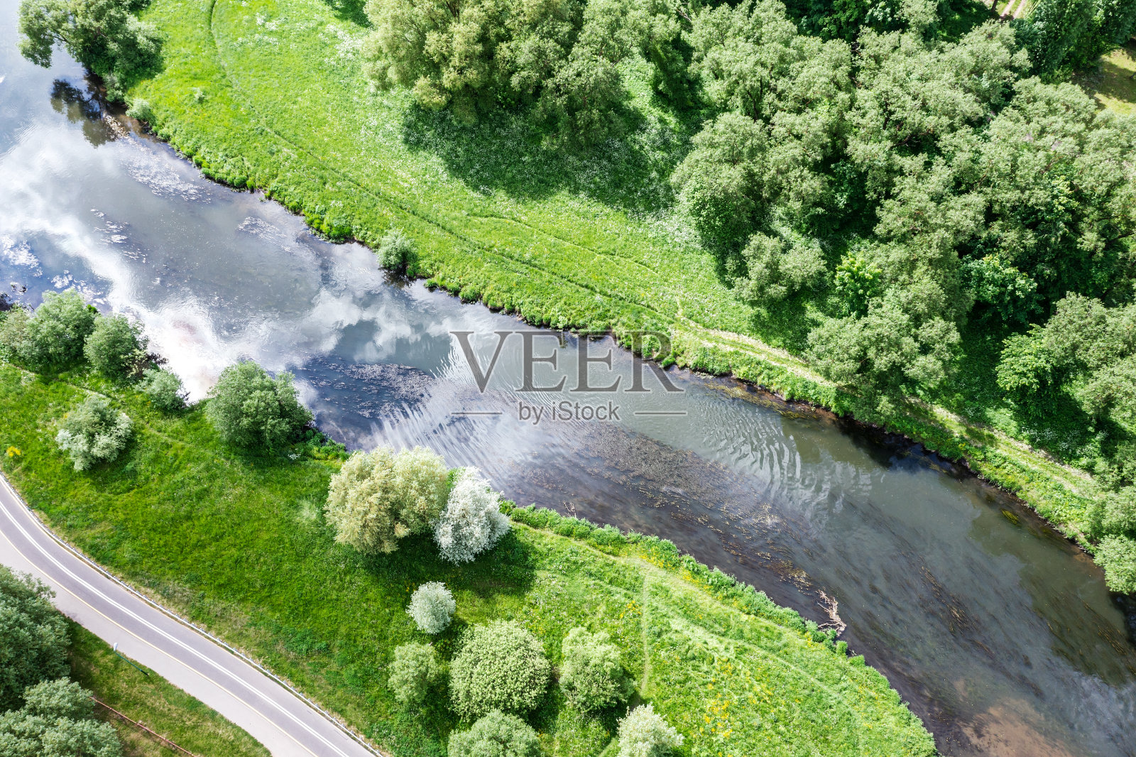 公园里有自行车道和人行道。夏季的景观有绿树和河流。空中无人机视图。照片摄影图片