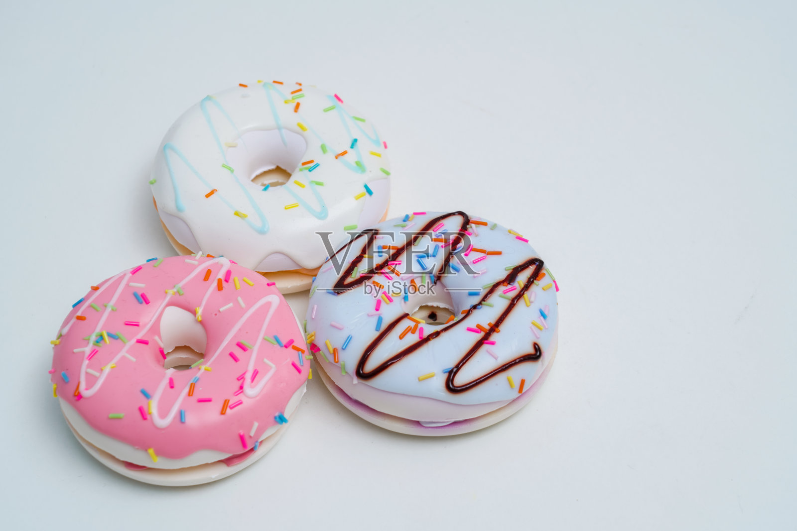 明亮多彩的甜甜圈放在纯色的背景上照片摄影图片