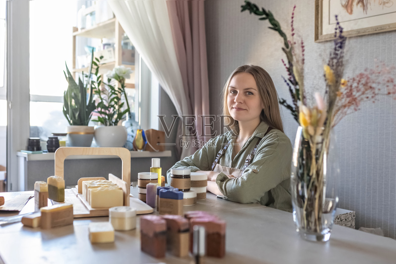 一个妇女肥皂制造商摆出并包装了新鲜准备的手工肥皂和身体护理化妆品。装配订单的过程。家庭spa。小生意。照片摄影图片