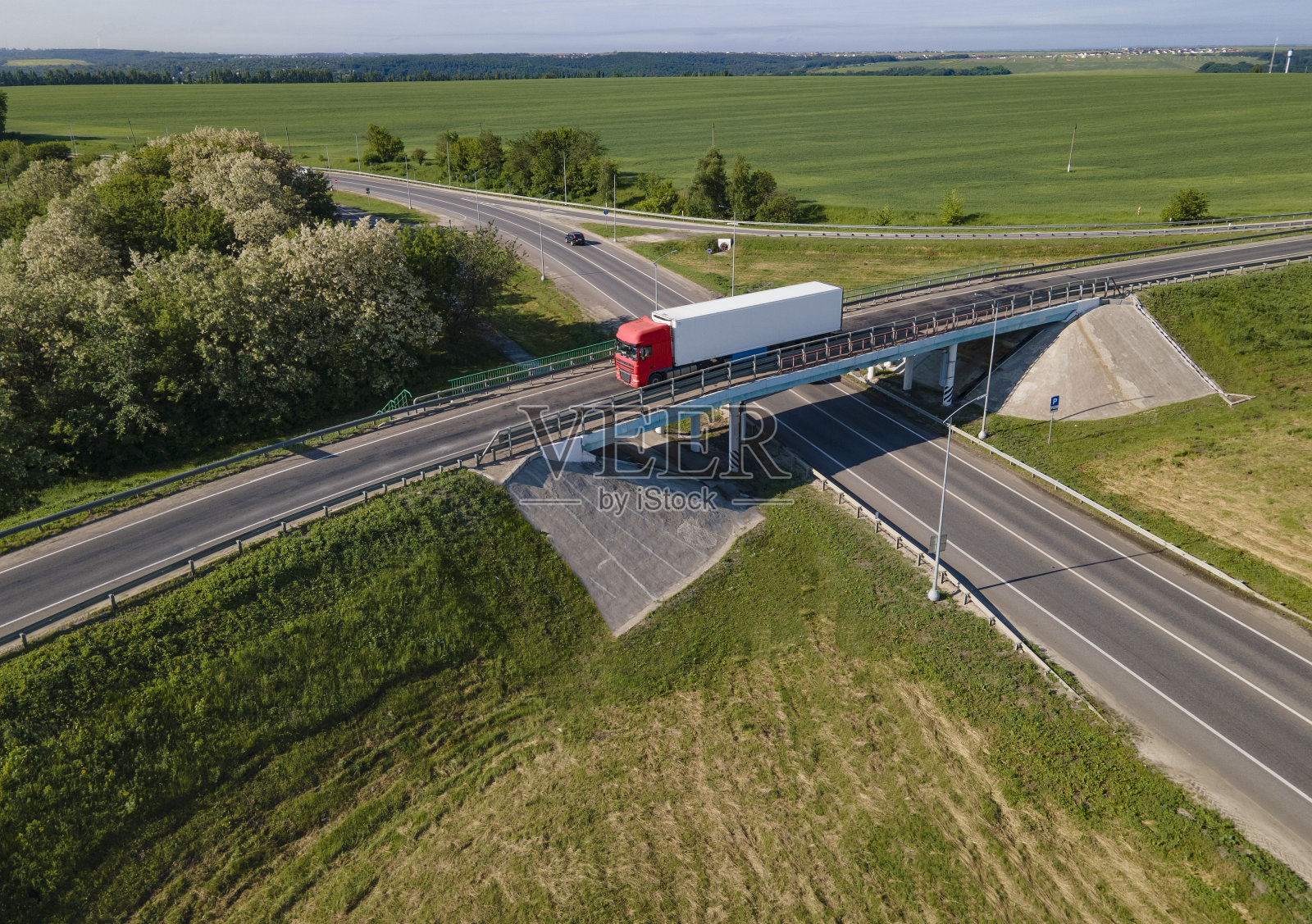 粉红色卡车与半挂车在道路上的方向。高速公路交叉结。空中俯视图照片摄影图片