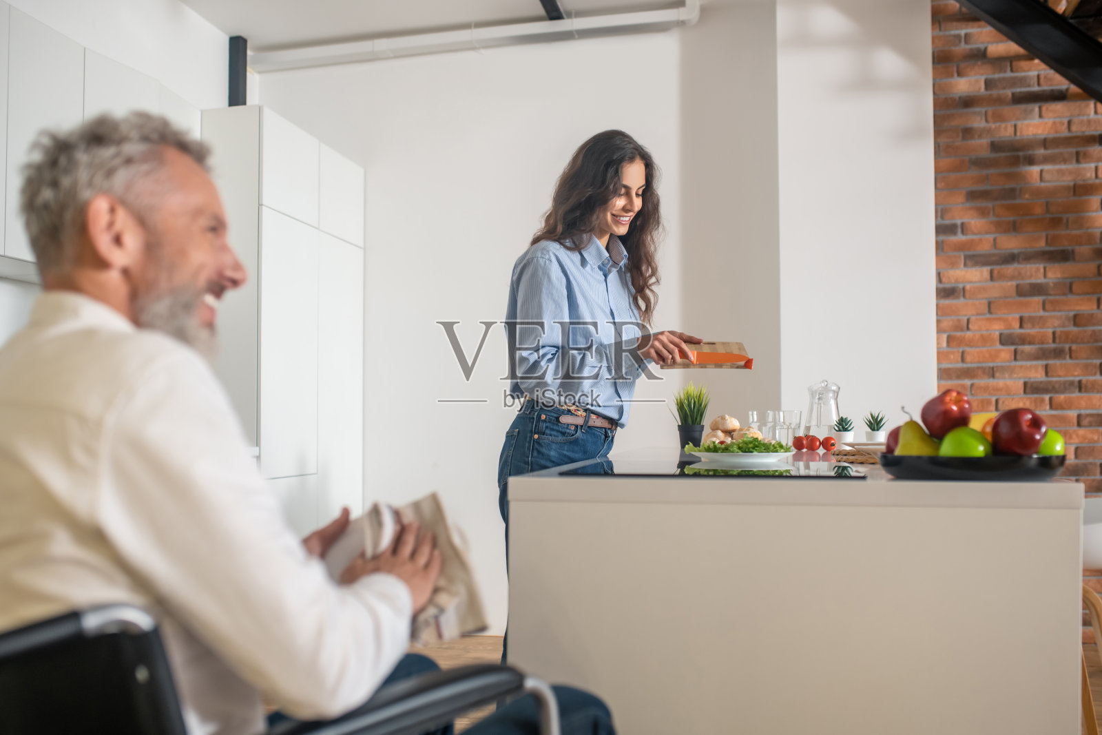 一个白发苍苍的残疾人和他的妻子在早餐前在家照片摄影图片