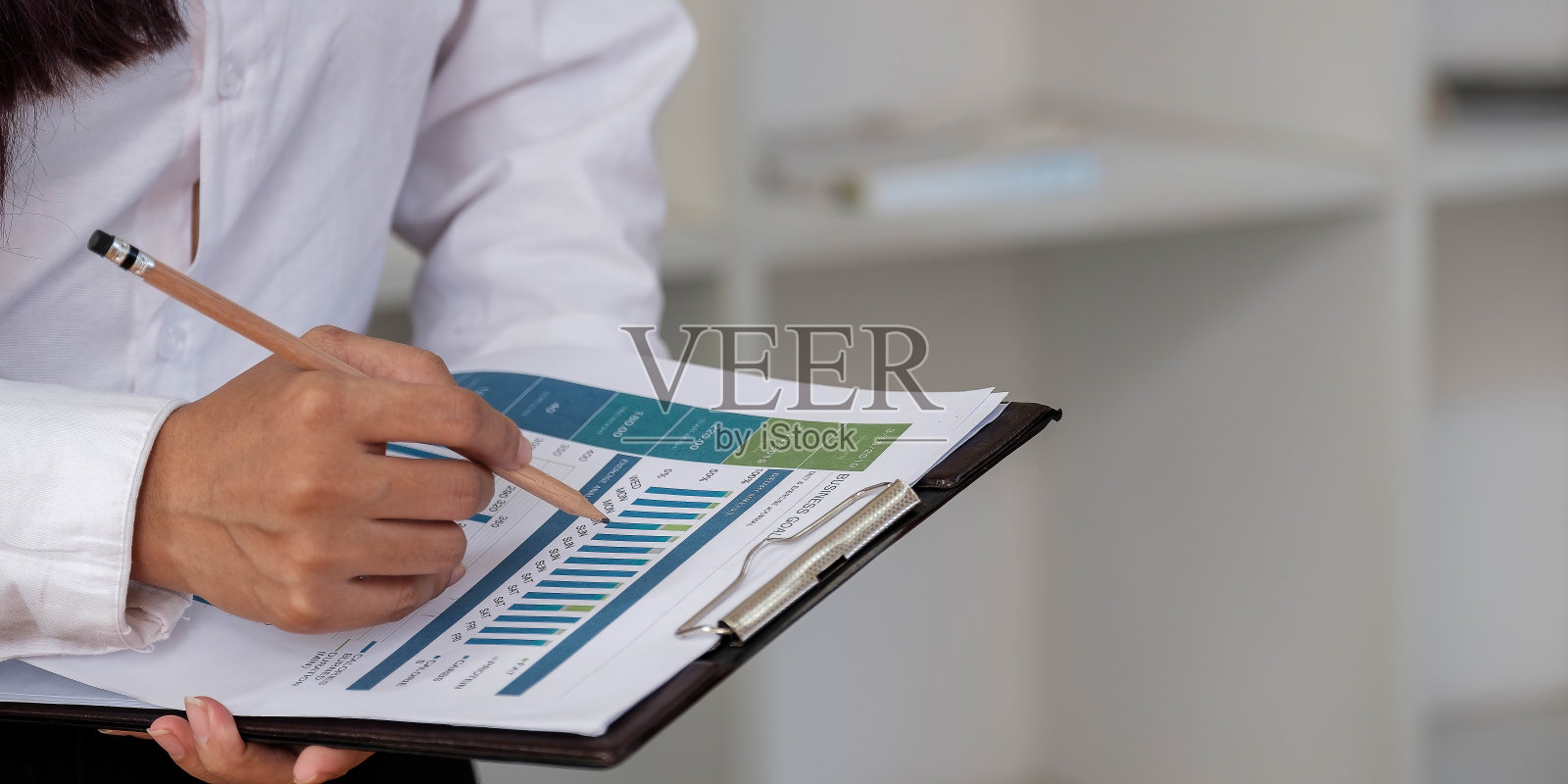 接近女商人投资顾问分析公司年度财务报告,资产负债表报表与文件图表。业务、市场、办公室、税务的概念图。照片摄影图片