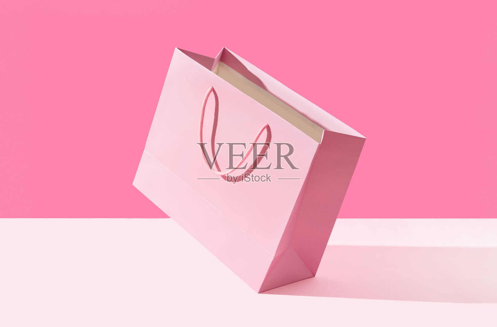 粉色背景的纸袋。购物销售配送概念照片摄影图片