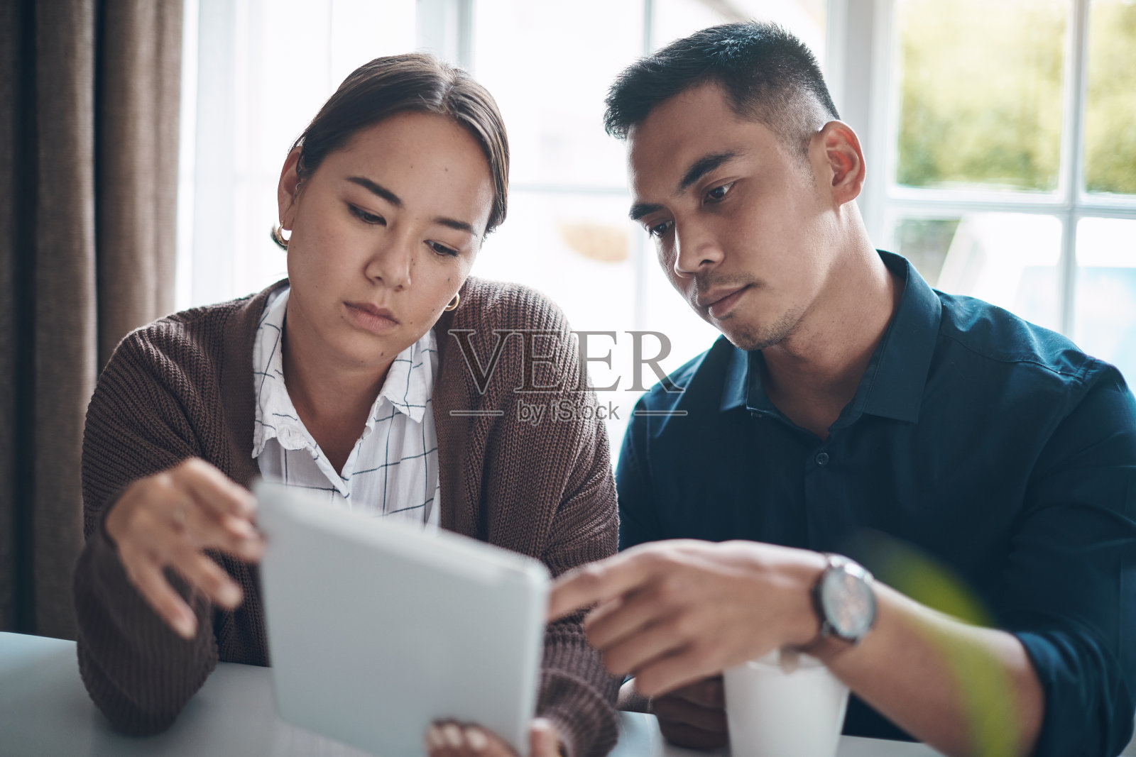 一对年轻夫妇在家里一起使用电子平板电脑的照片照片摄影图片