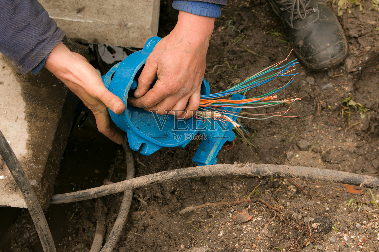 一个电工的双手正在组装一箱电气设备。公园户外照明维护工作。照片摄影图片