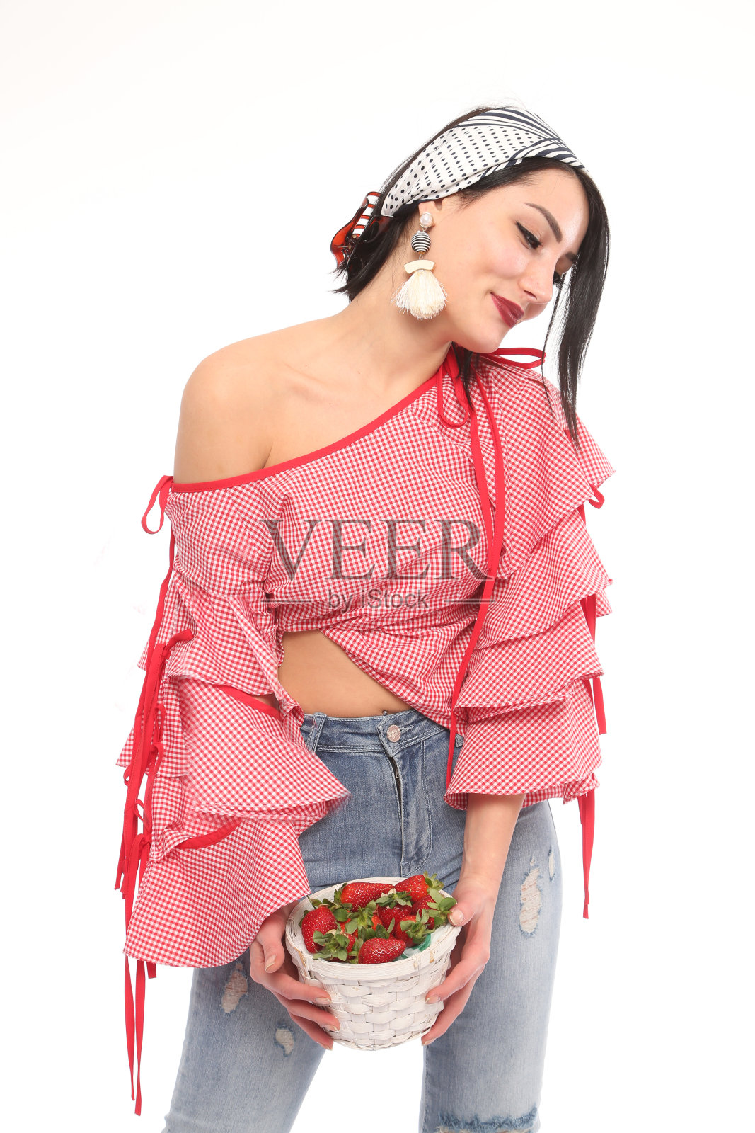 年轻漂亮的女人,在白色的背景下,挎着一篮草莓。照片摄影图片