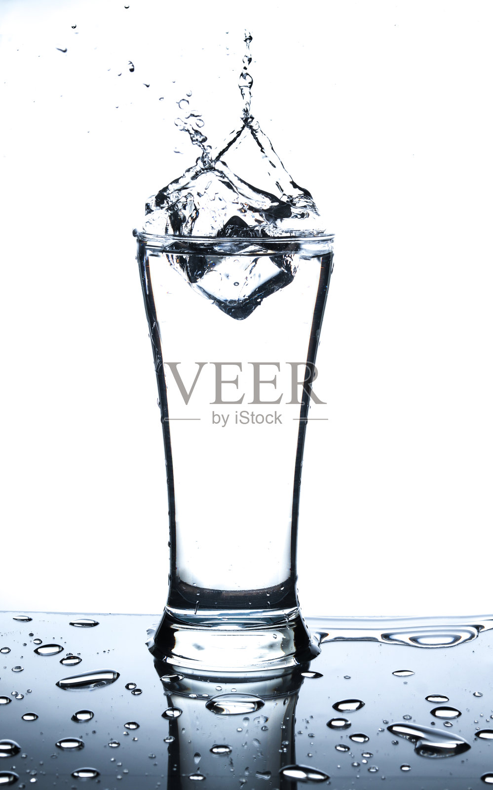 冰在一杯水和溅在白色的背景照片摄影图片
