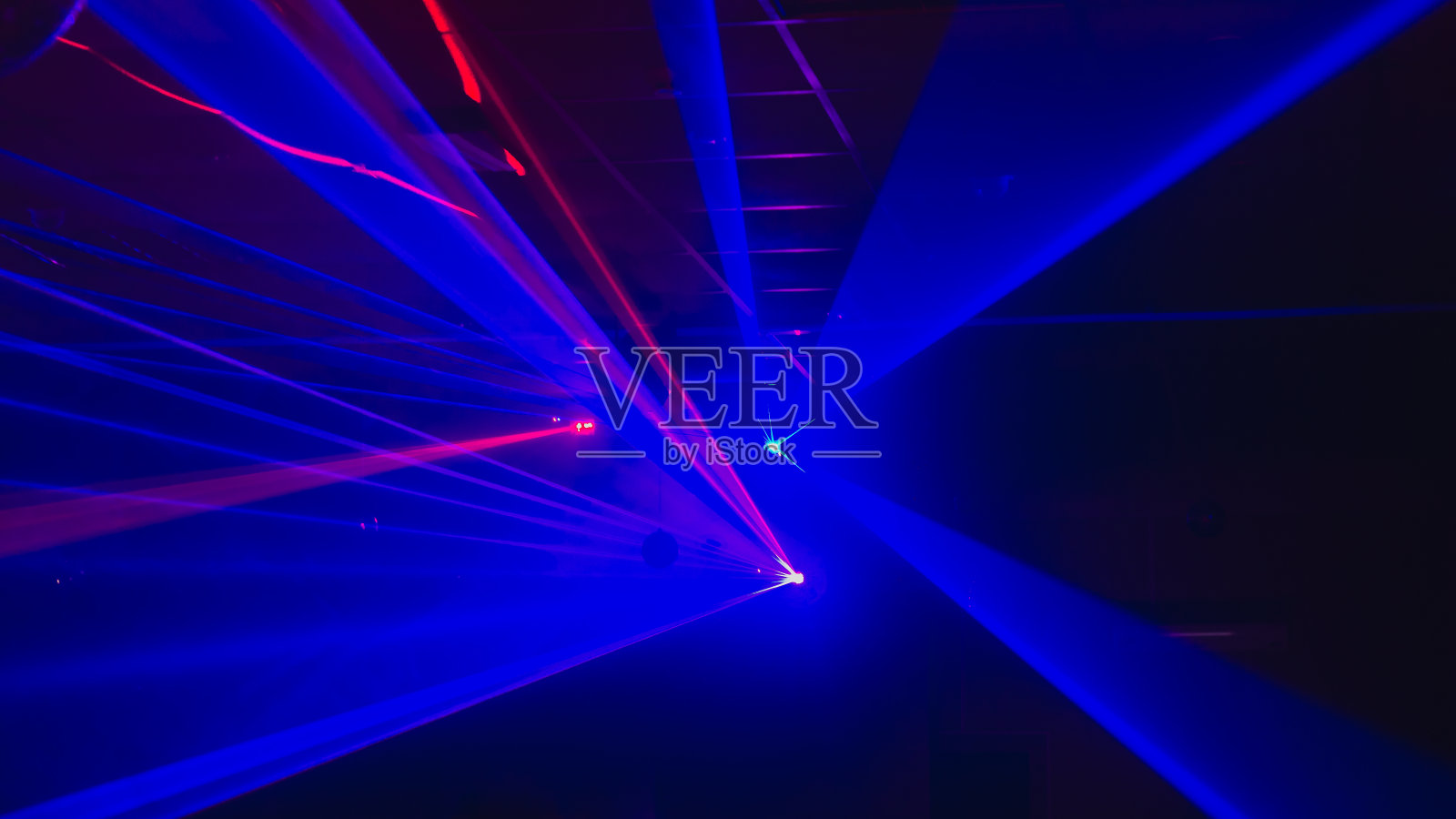 模糊的背景与激光蓝色灯光的迪斯科舞厅,舞池照片摄影图片