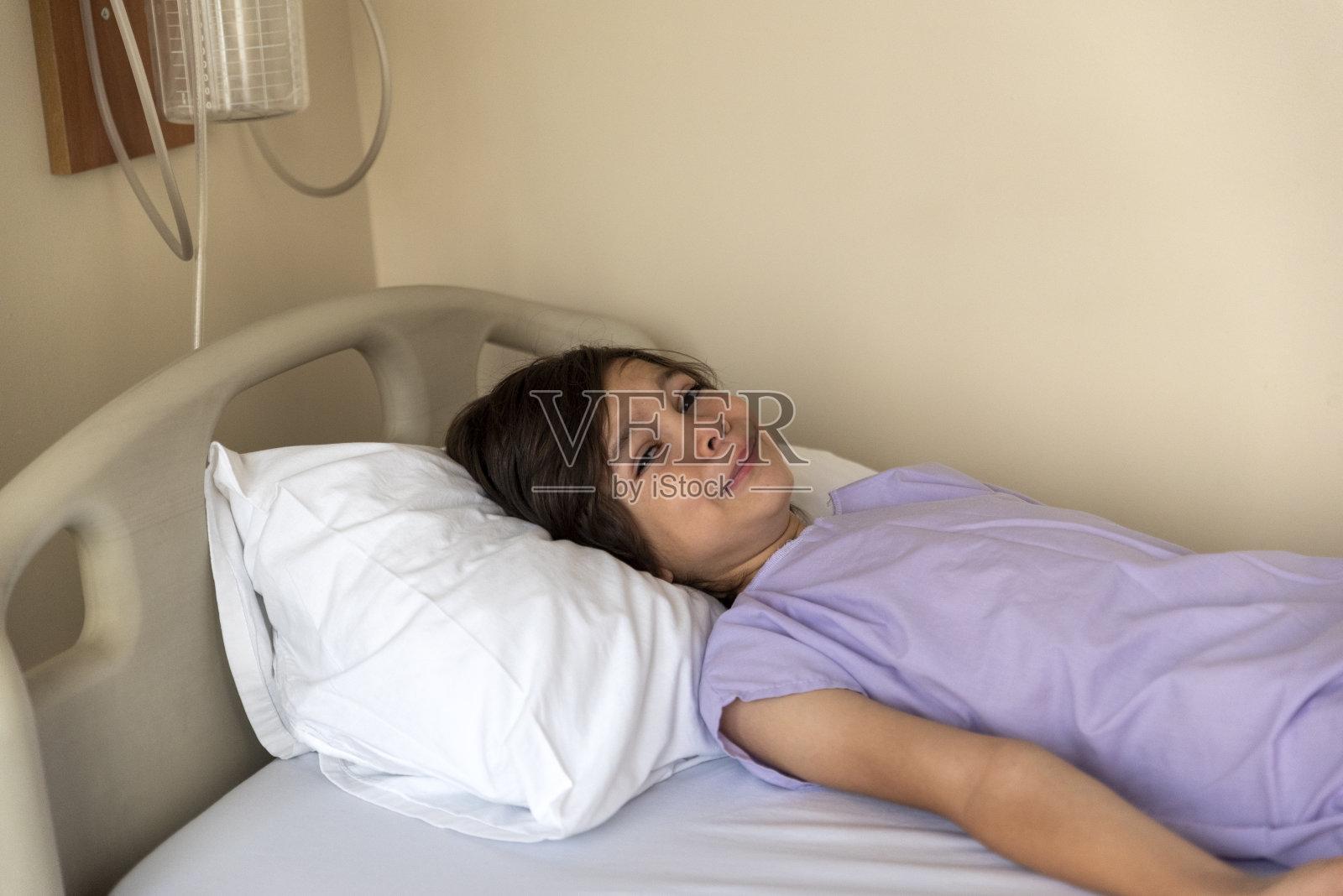 在病房的病床上等待手术的男孩照片摄影图片