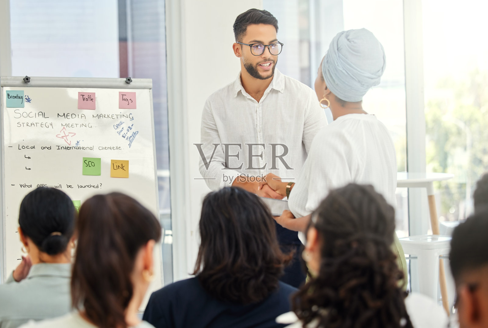 两个年轻的商人在会议期间握手的镜头照片摄影图片