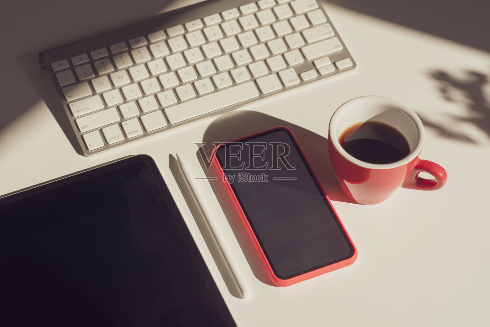 桌子上放着一个咖啡杯,平板电脑,手机,电脑。P,平板,手机,电脑放置。照片摄影图片