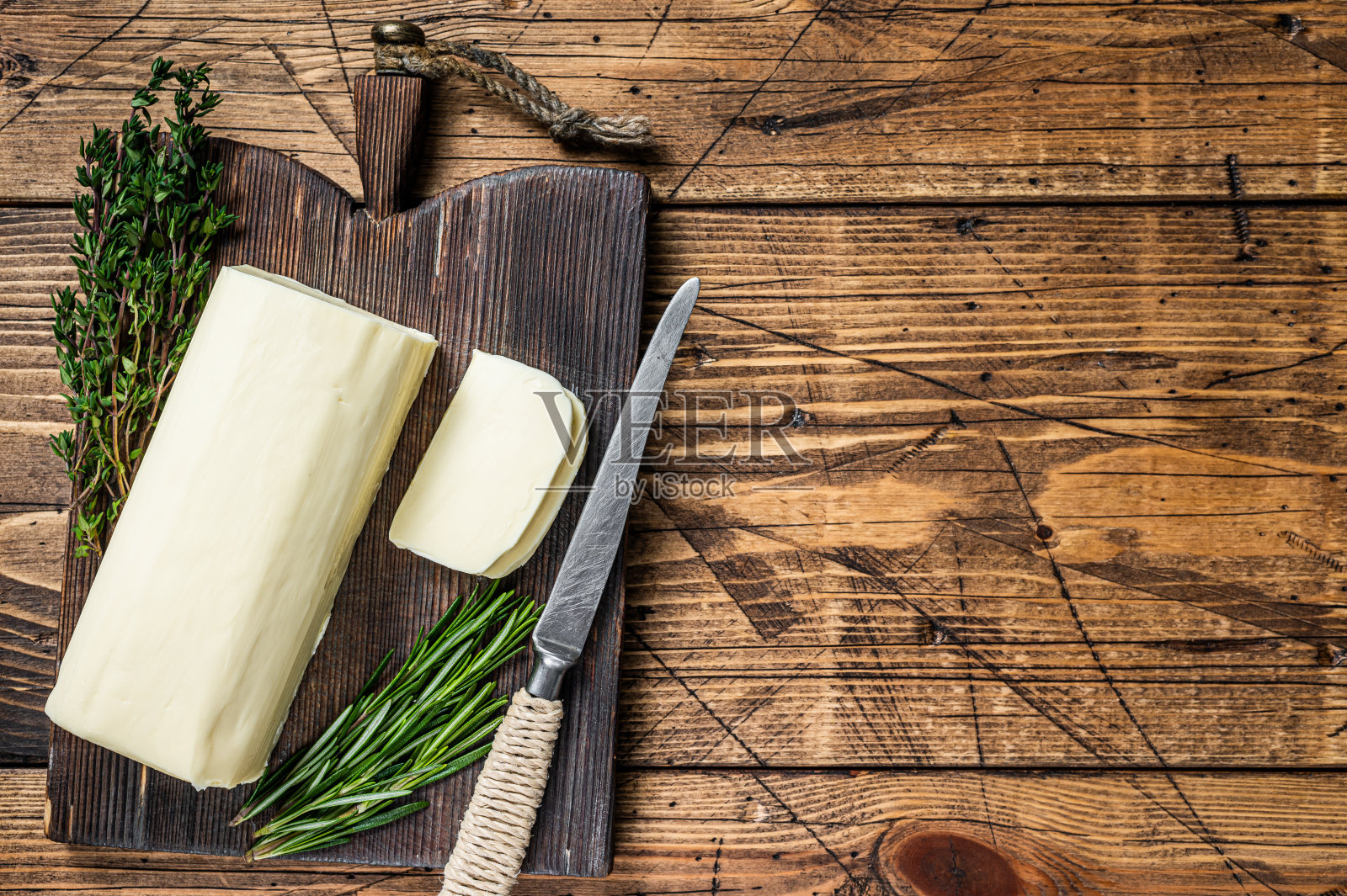 黄油切片铺在木板上与香草。木制背景。前视图。本空间照片摄影图片