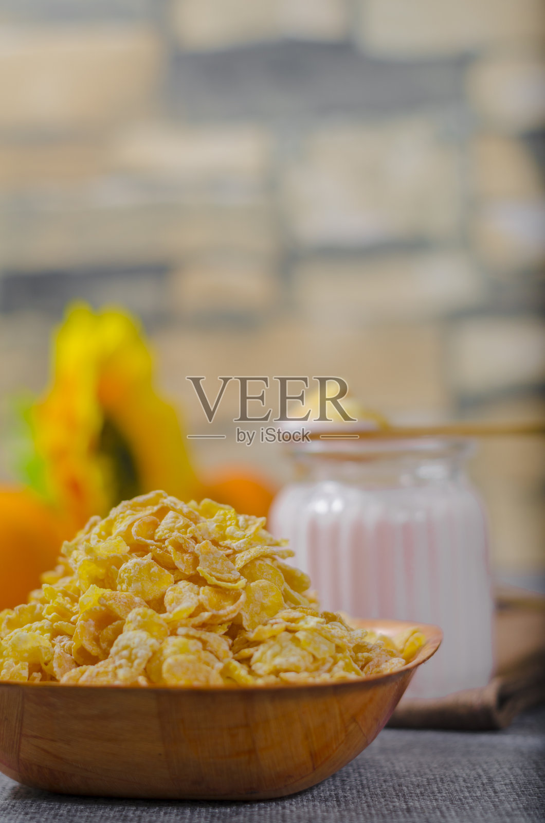 酸奶与天然无麸质小麦谷物,新鲜橙水果在一个玻璃杯和一个木碗。与copyspace的文本空间。希腊照片摄影图片