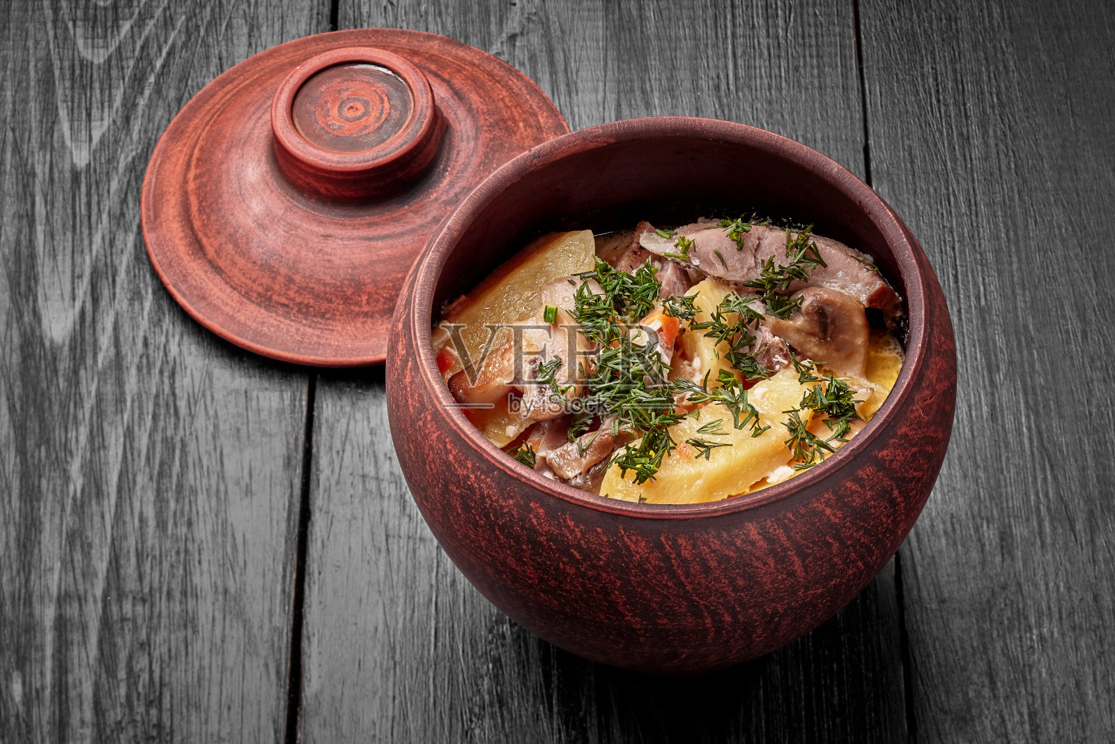 配猪肉、土豆和蘑菇在砂锅里烤照片摄影图片