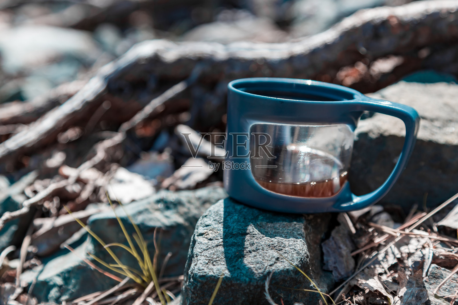 石头上放着一个盛热饮的杯子照片摄影图片