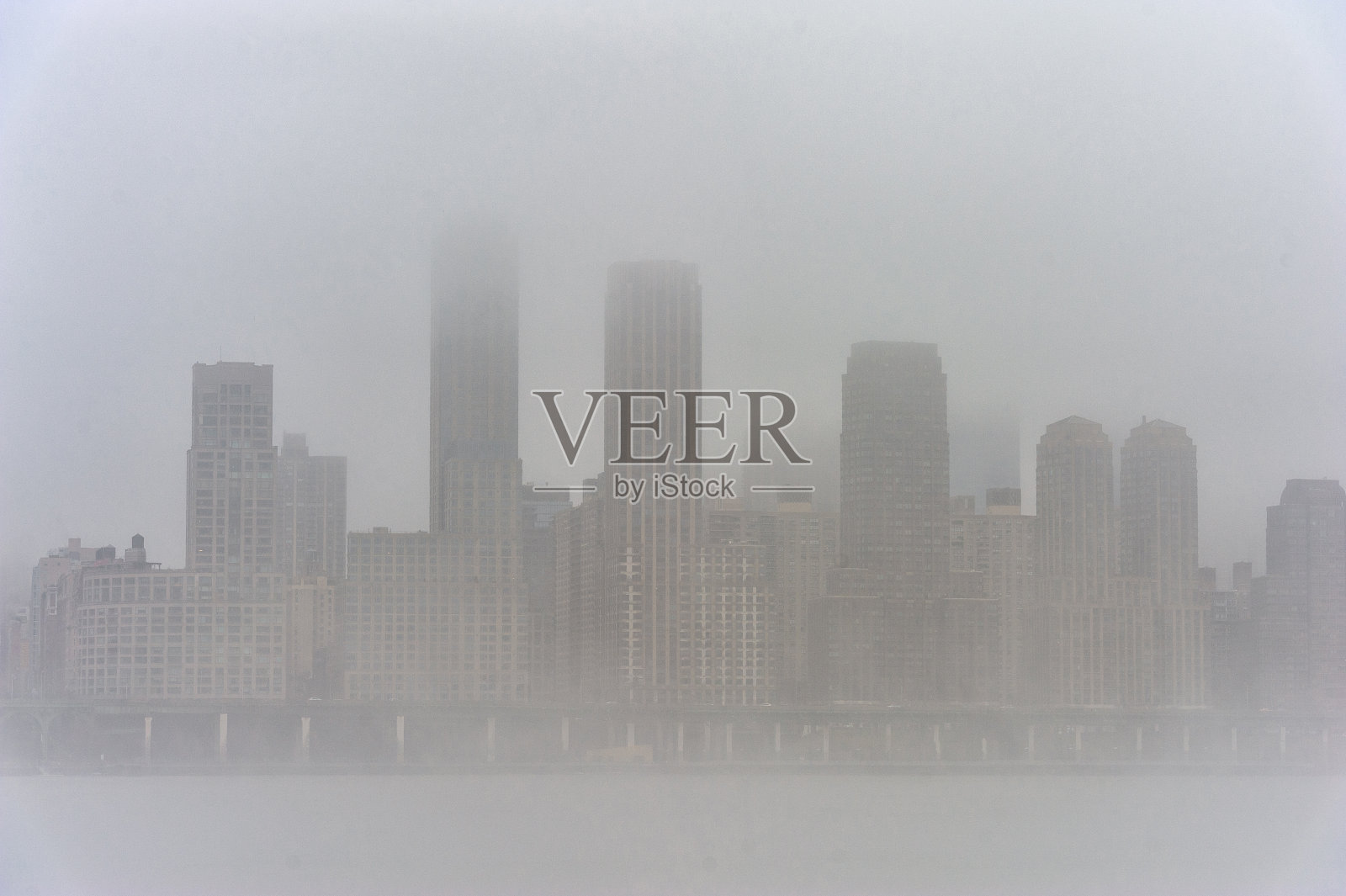 冬天的哈德逊河与朦胧的纽约城市景观背景。照片摄影图片