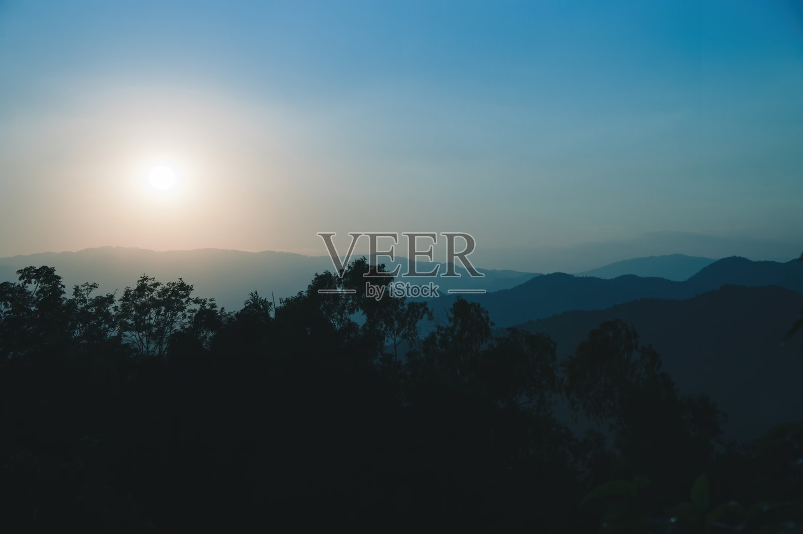 山顶日落景色,树枝聚焦,主体部分模糊照片摄影图片