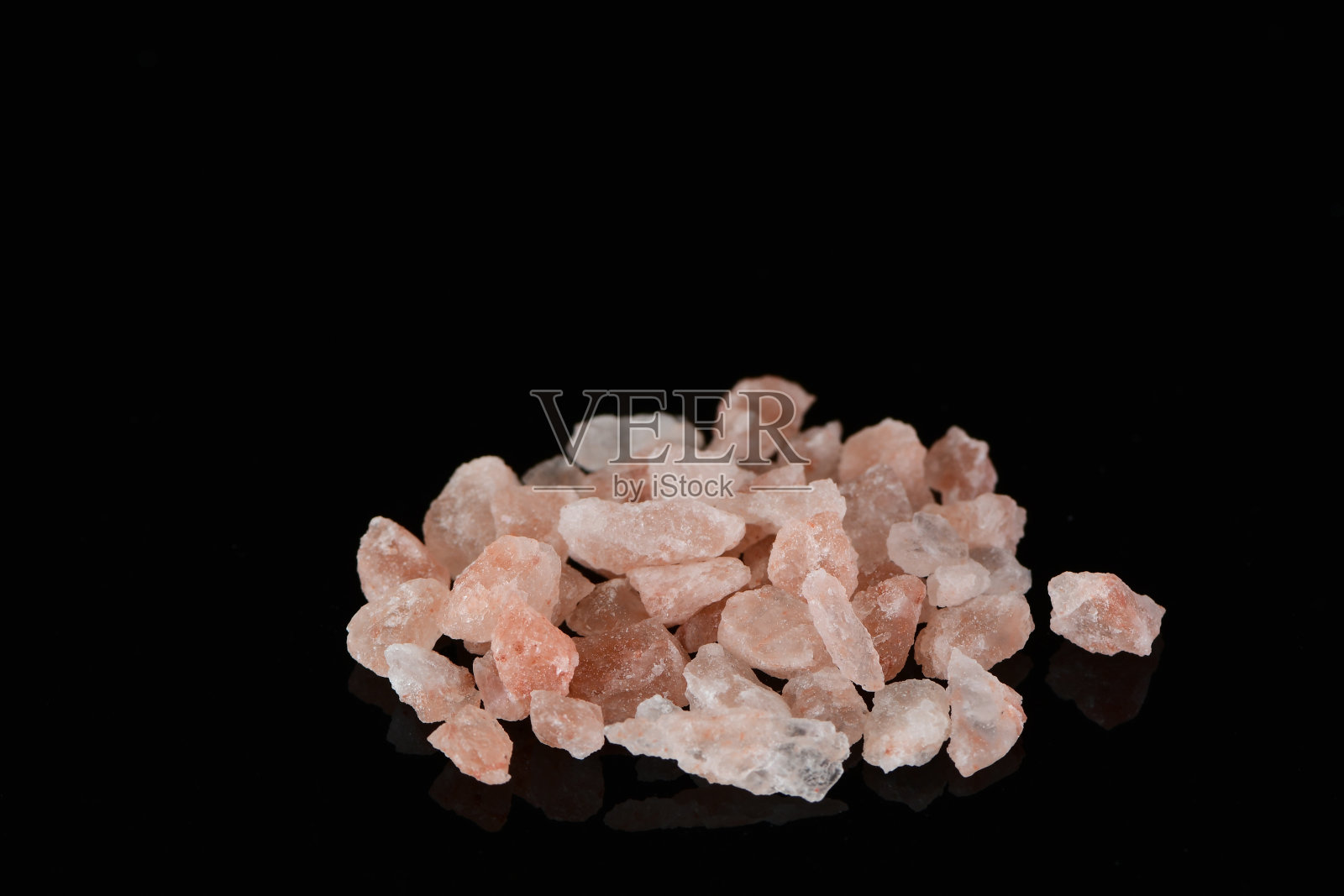 粉红色的喜马拉雅盐在黑色的背景照片摄影图片