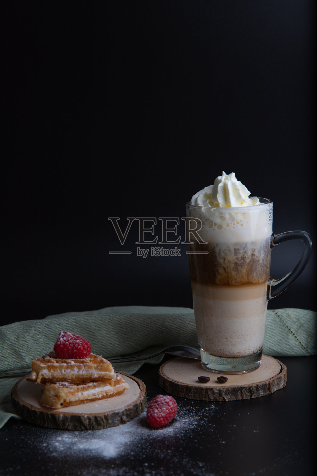 新鲜出炉的华夫饼配上树莓、糖粉和咖啡拿铁玛奇朵放在木盘子里照片摄影图片