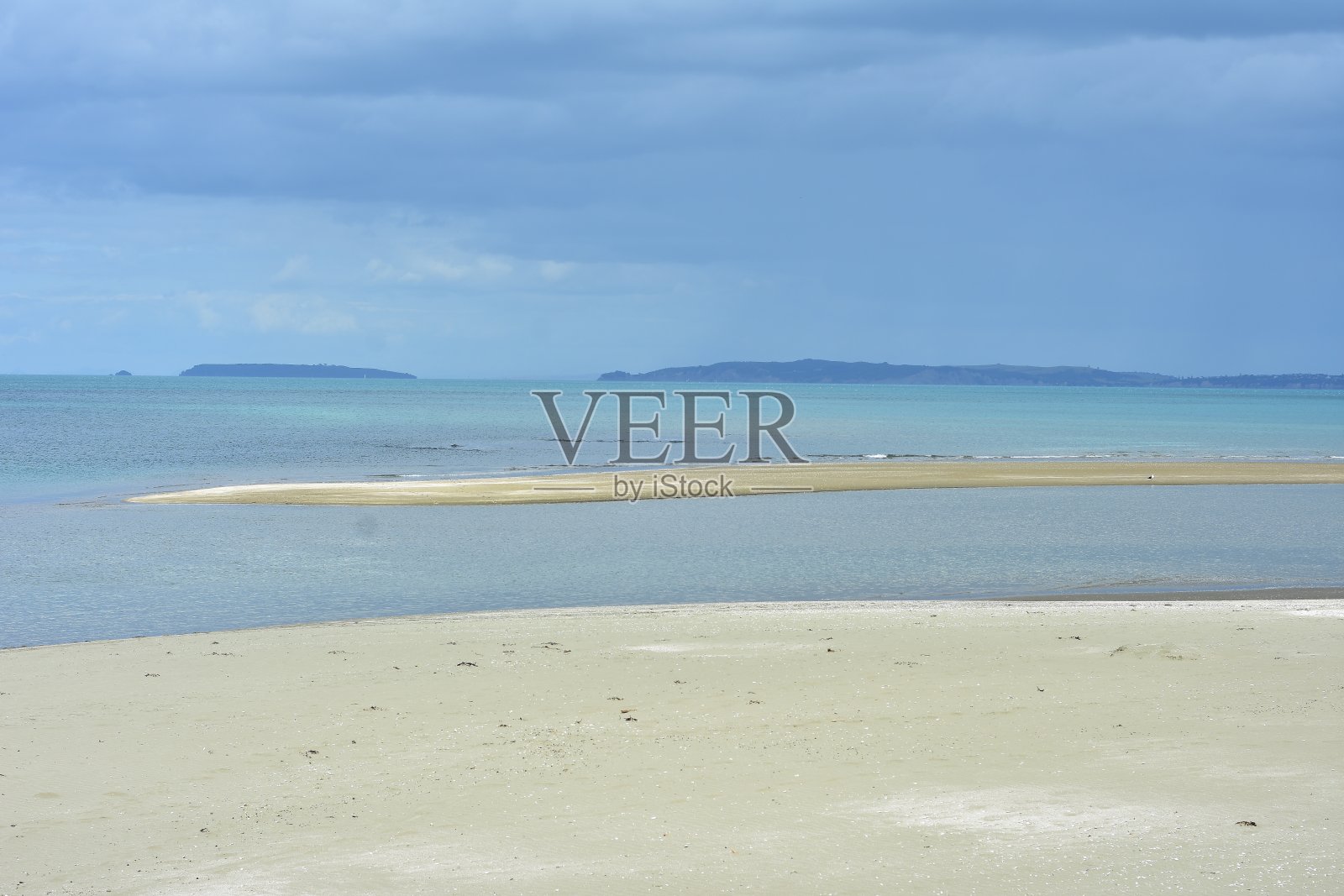 平静的海面上的沙地照片摄影图片