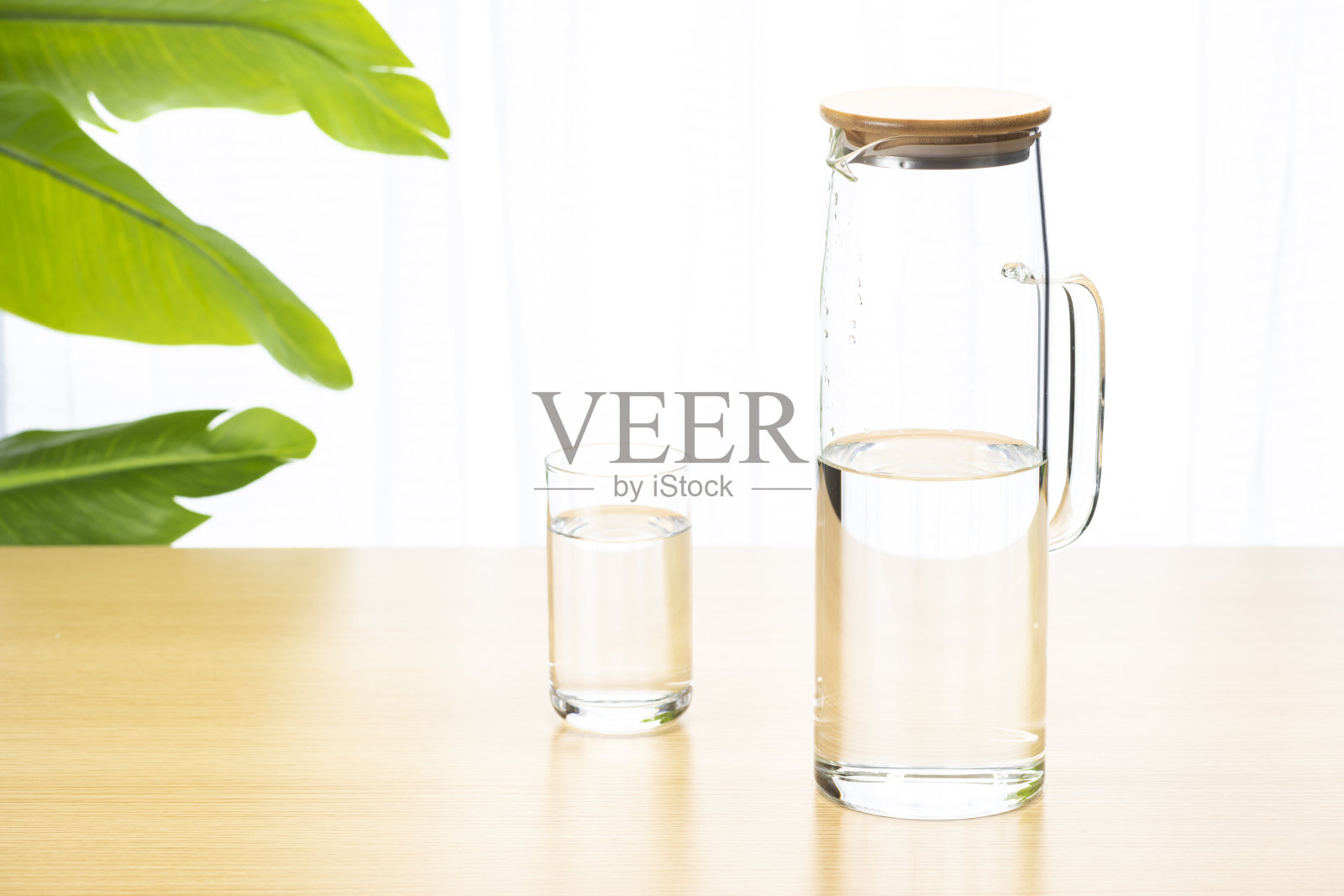 用桌子上的杯子喝水。照片摄影图片