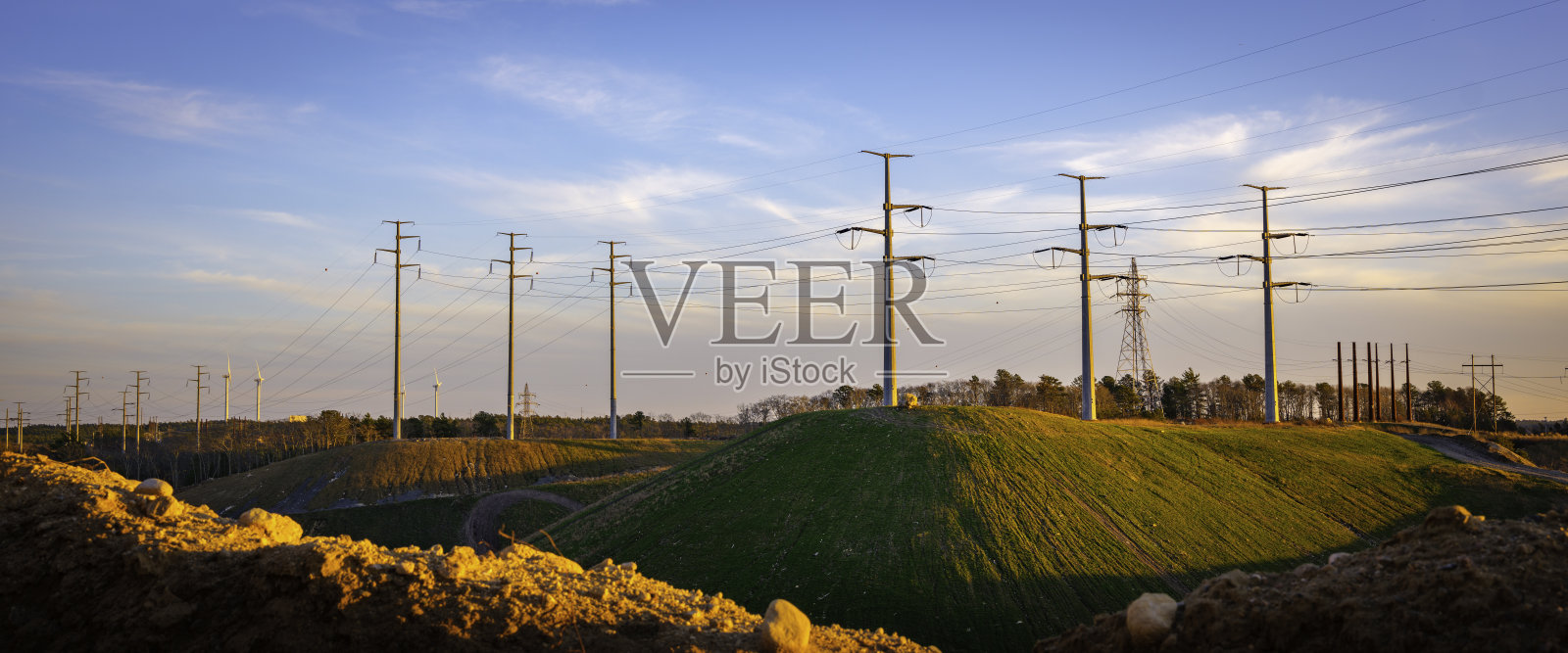 工业景观与山上的电力塔。蓝天上的电线杆和电缆上戏剧性的云景。复古技术背景图像与空间的文字或设计照片摄影图片