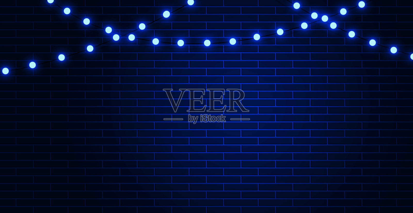 霓虹花环在深蓝的砖墙背景上照片摄影图片