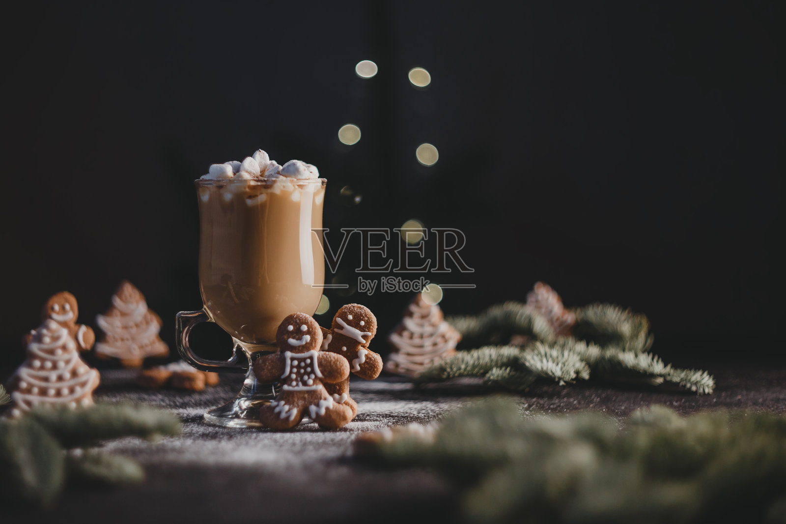 圣诞姜饼人,戴着医用防护面具。可可和棉花糖。新年的概念。新的现实。低调。照片摄影图片